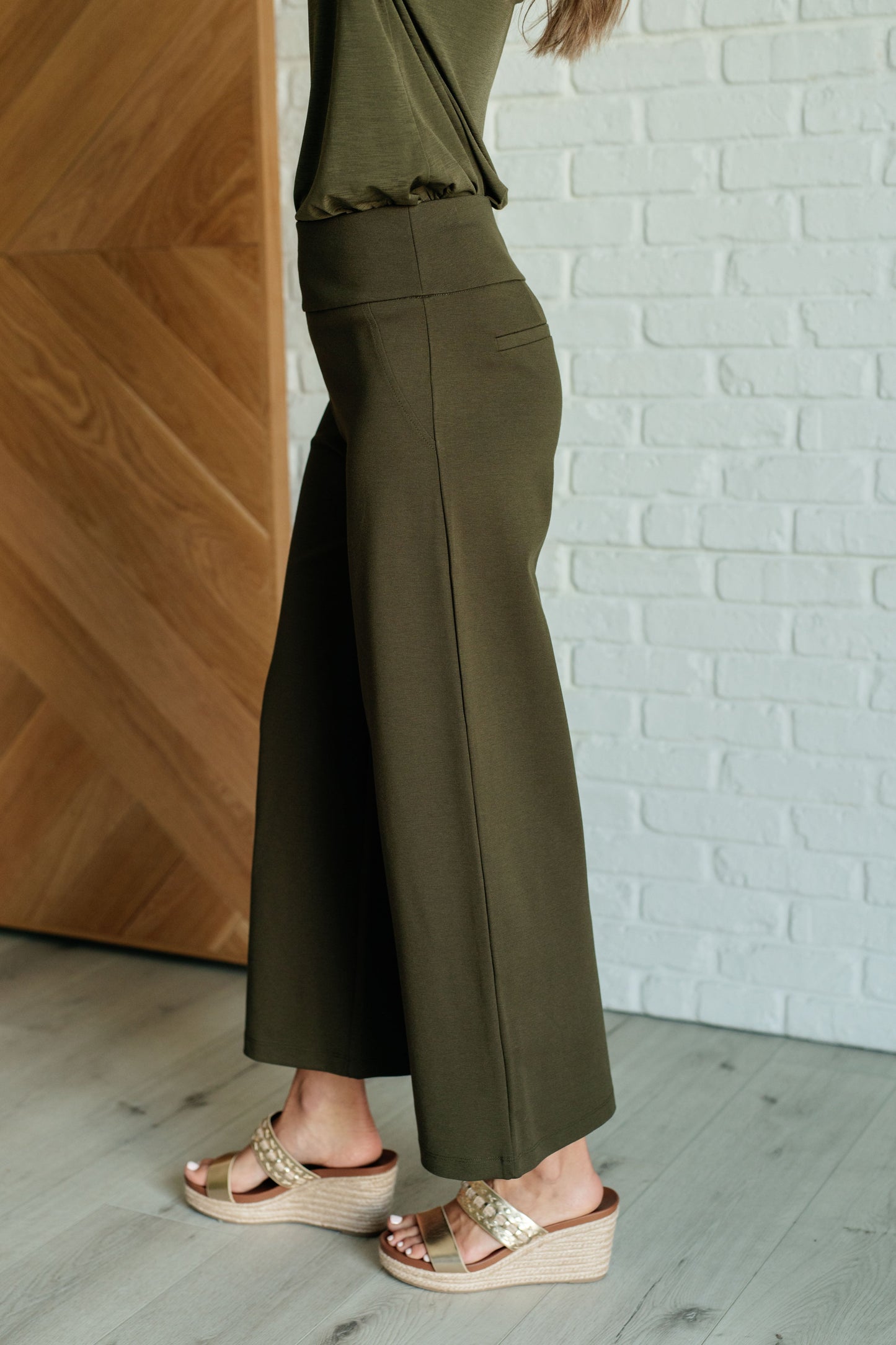 Olive ponte knit crop pants with wide leg silhouette, cropped length, high-rise waist, and smooth side fit.