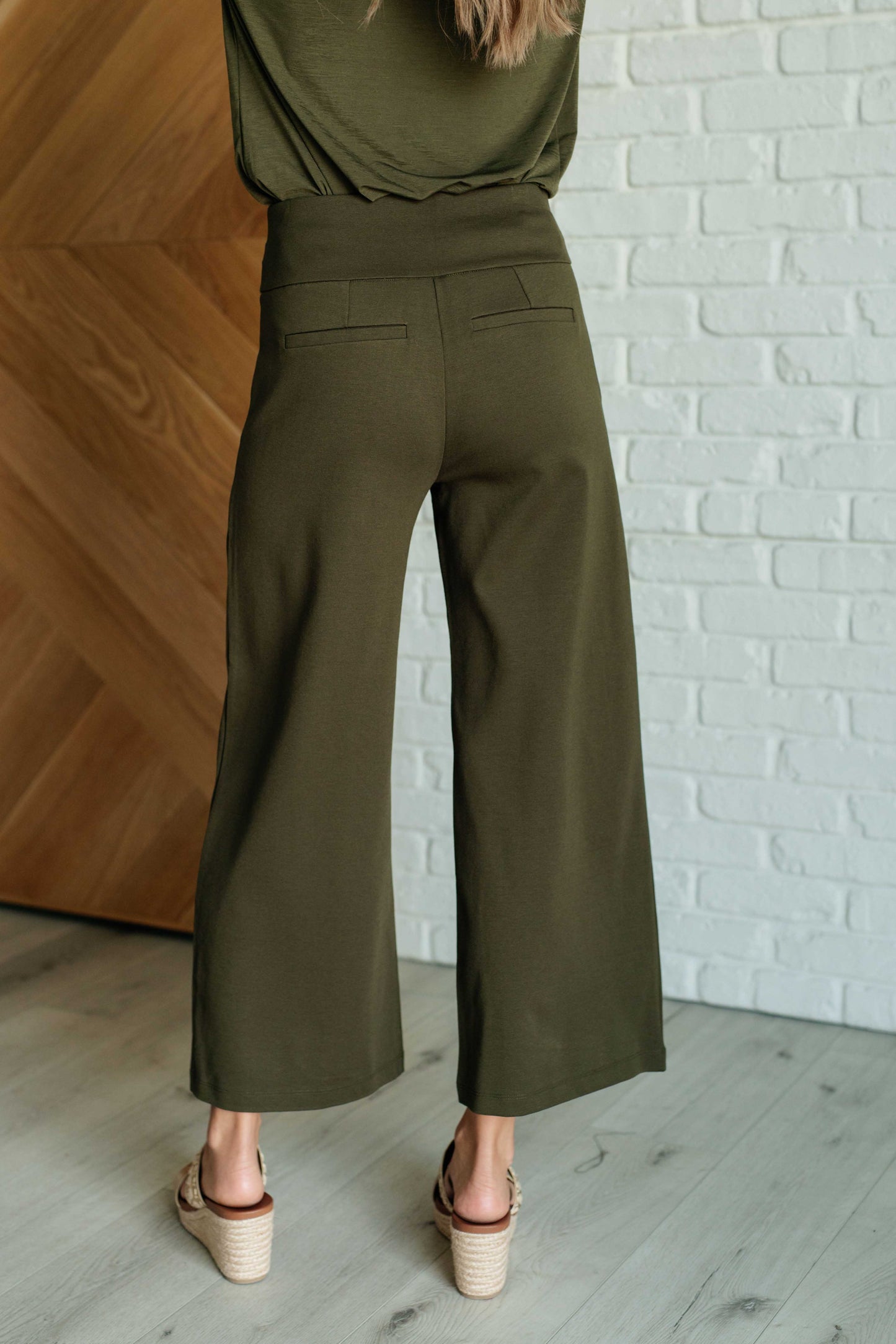 Olive ponte knit wide leg crop pants, cropped cut, high-rise fit, and sleek back with faux welt pocket.