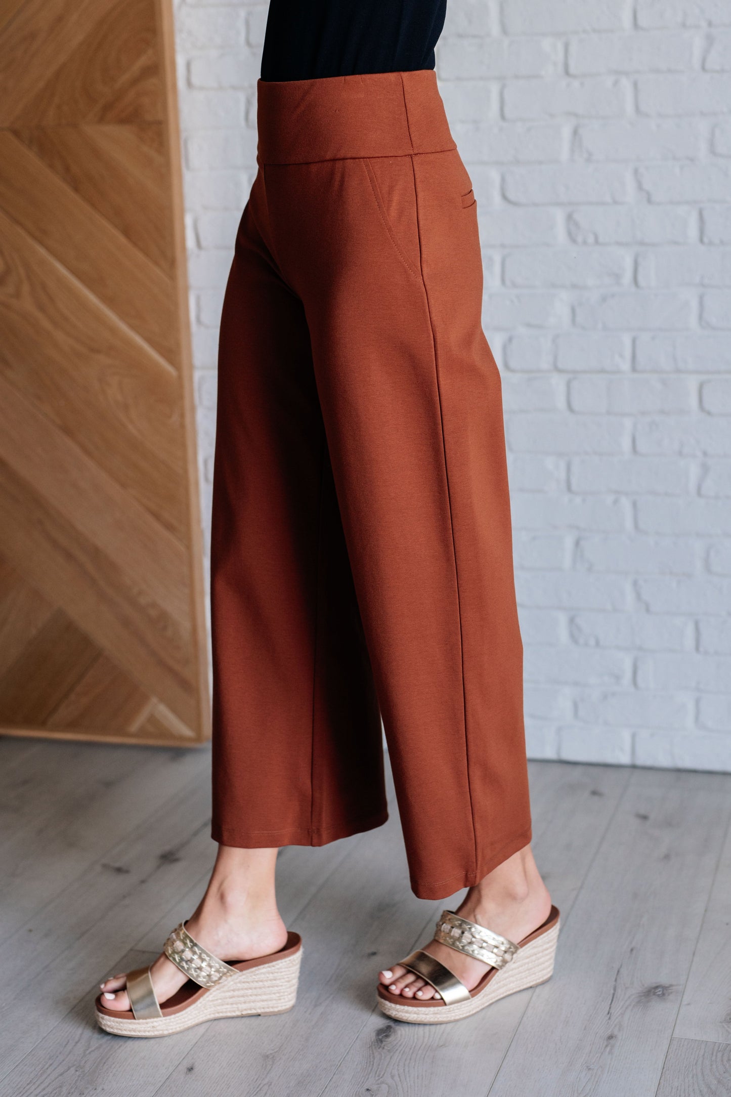 Rust high-rise wide leg pants in ponte knit, cropped hem, sleek wide leg shape with faux welt pocket detail.