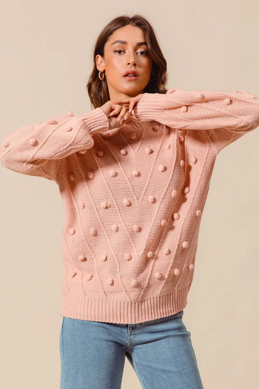 Front view of Marcella blush sweater showing textured pom pom knit and slightly stretchy fabric fit