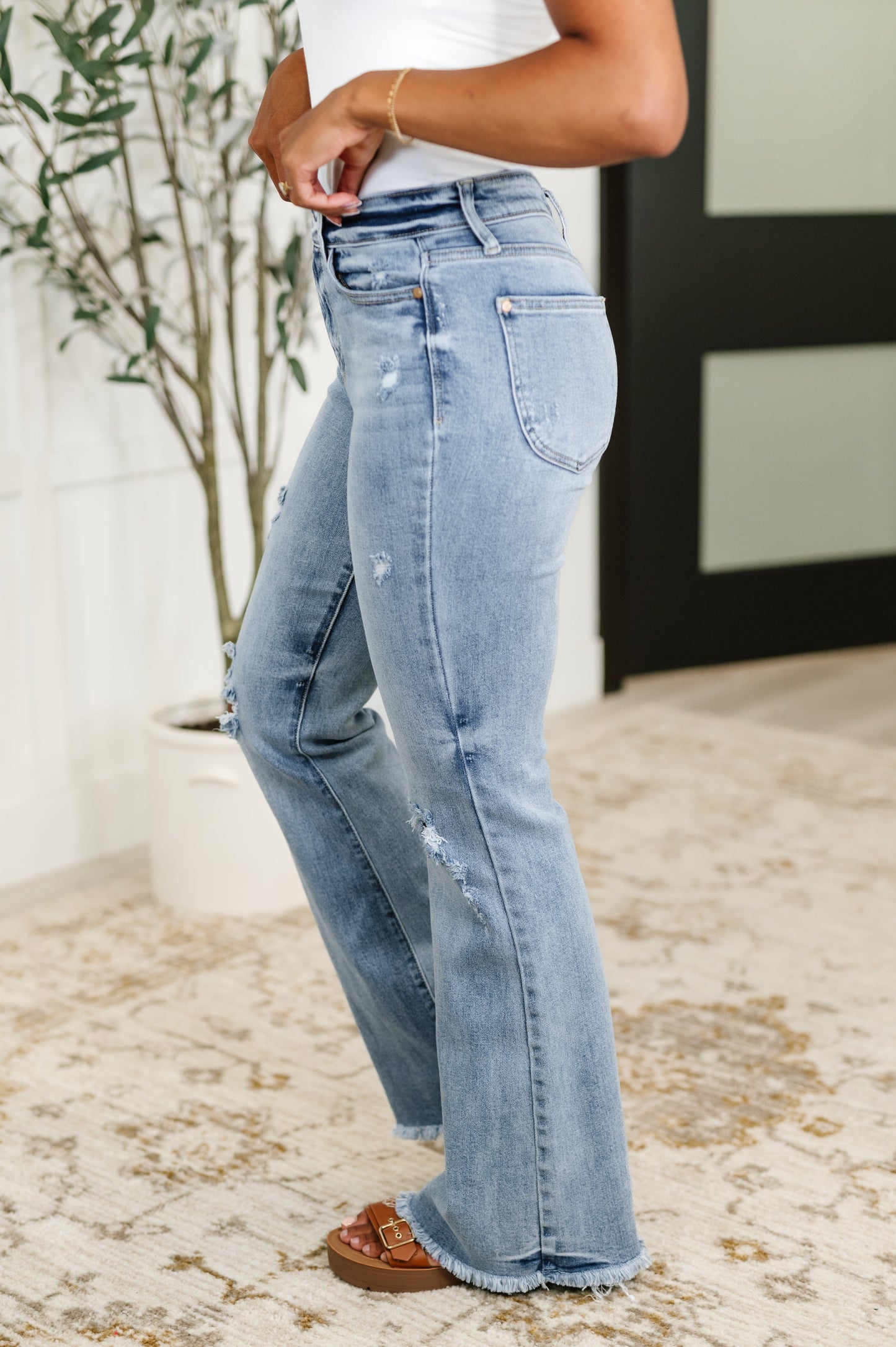 Side view of Marlena High Rise Flare Jeans showing flared silhouette, light wash denim, and curve-flattering fit.