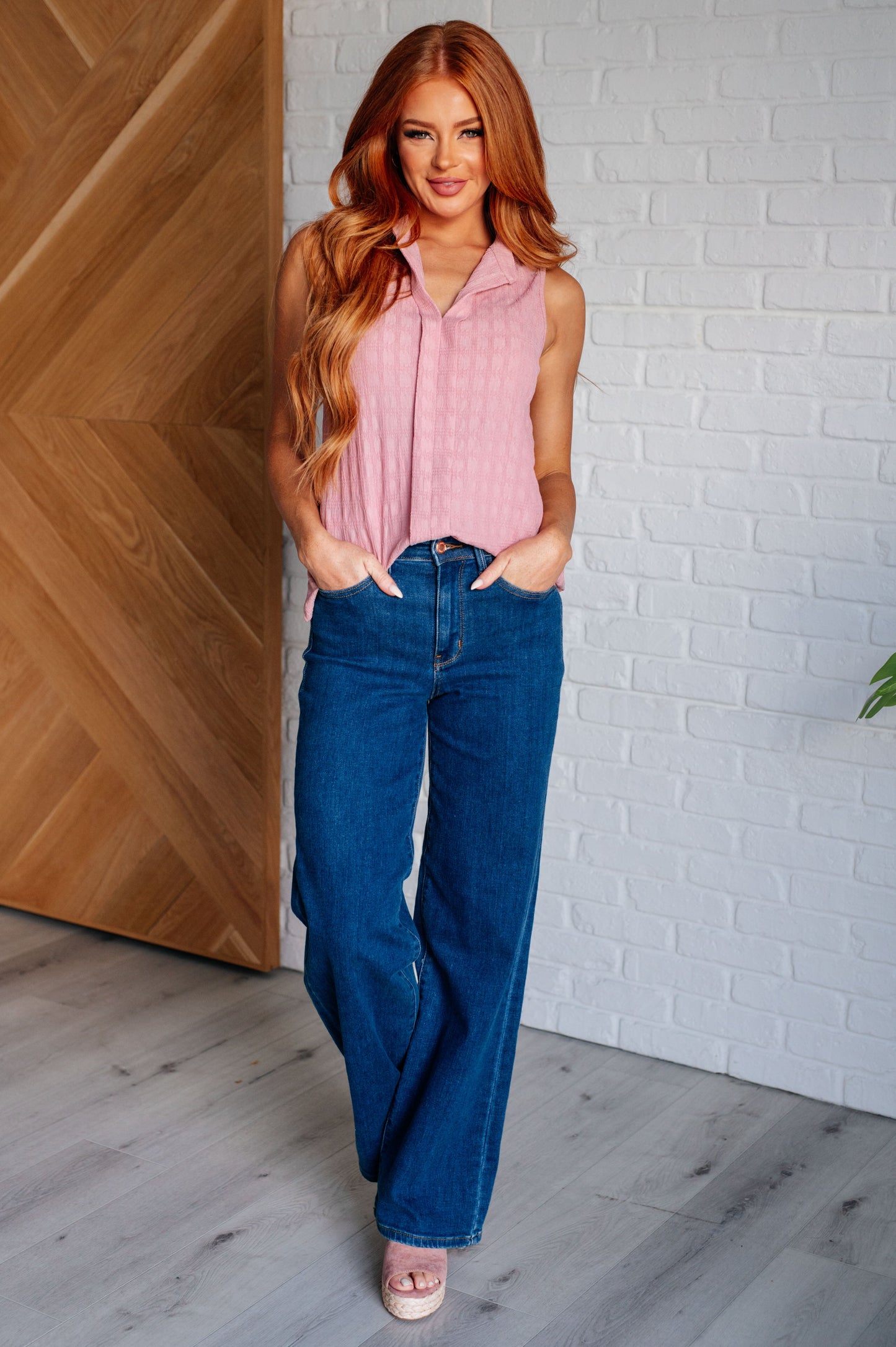 Full body view of model wearing Eva blouse in pink styled with trousers for chic everyday look.