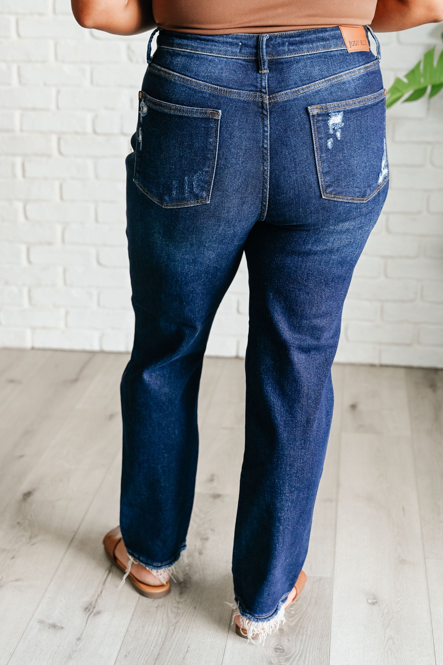 Plus size model back view in Montana High Rise Distressed Straight Leg Jeans.