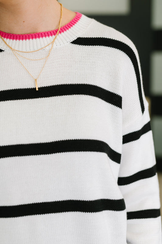 Detail of Daphne Striped Sweater showing ribbed pink neckline with black-and-white stripe knit.