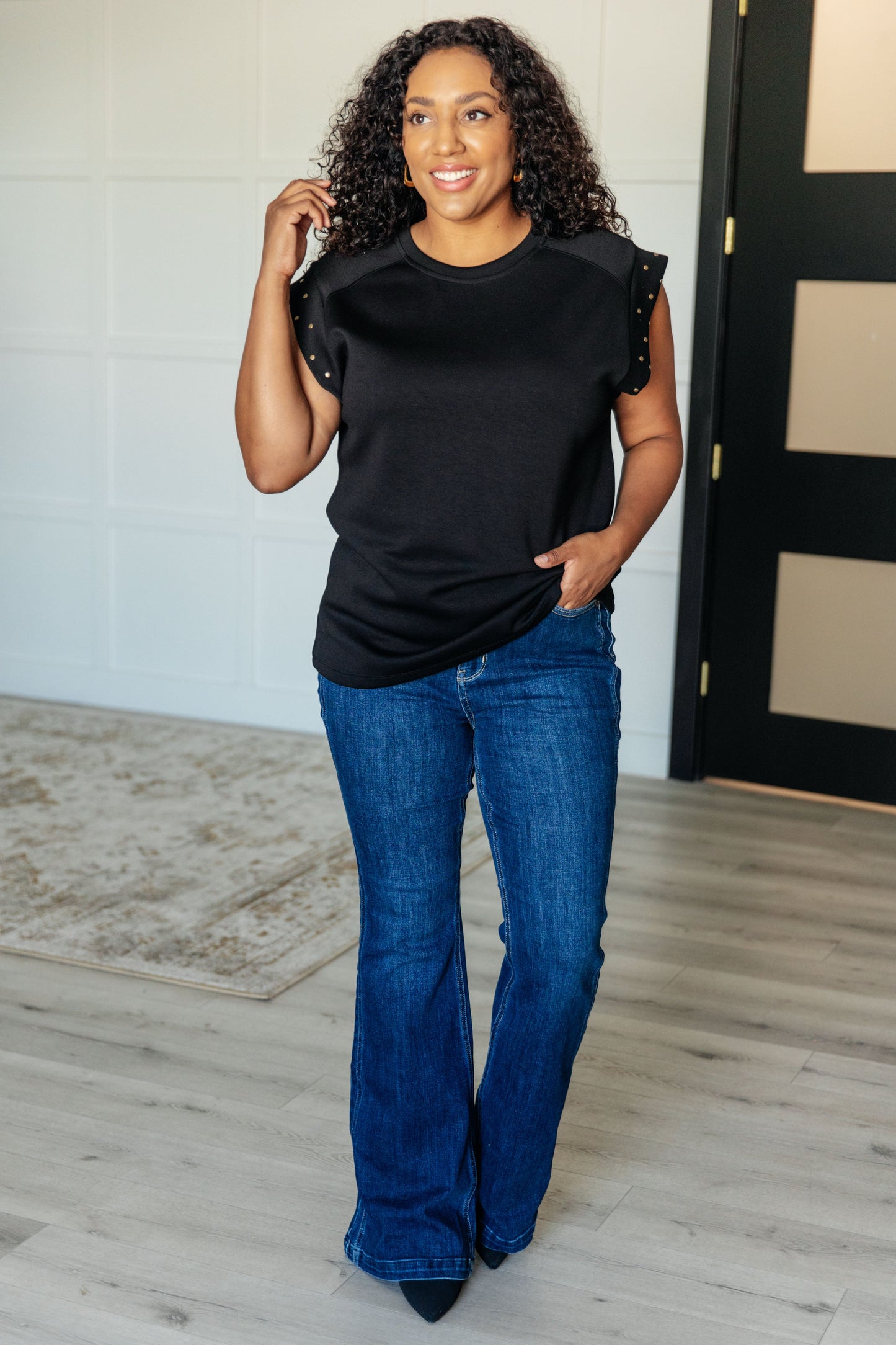 Plus size model full body wearing Myla Black Studded Cap Sleeve Top with stretchy knit fabric.