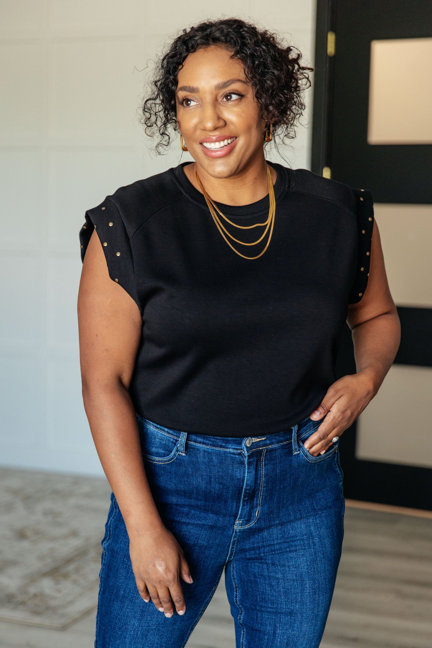 Plus size model wearing Myla Curvy Plus Studded Cap Sleeve Top in black knit with round neckline.