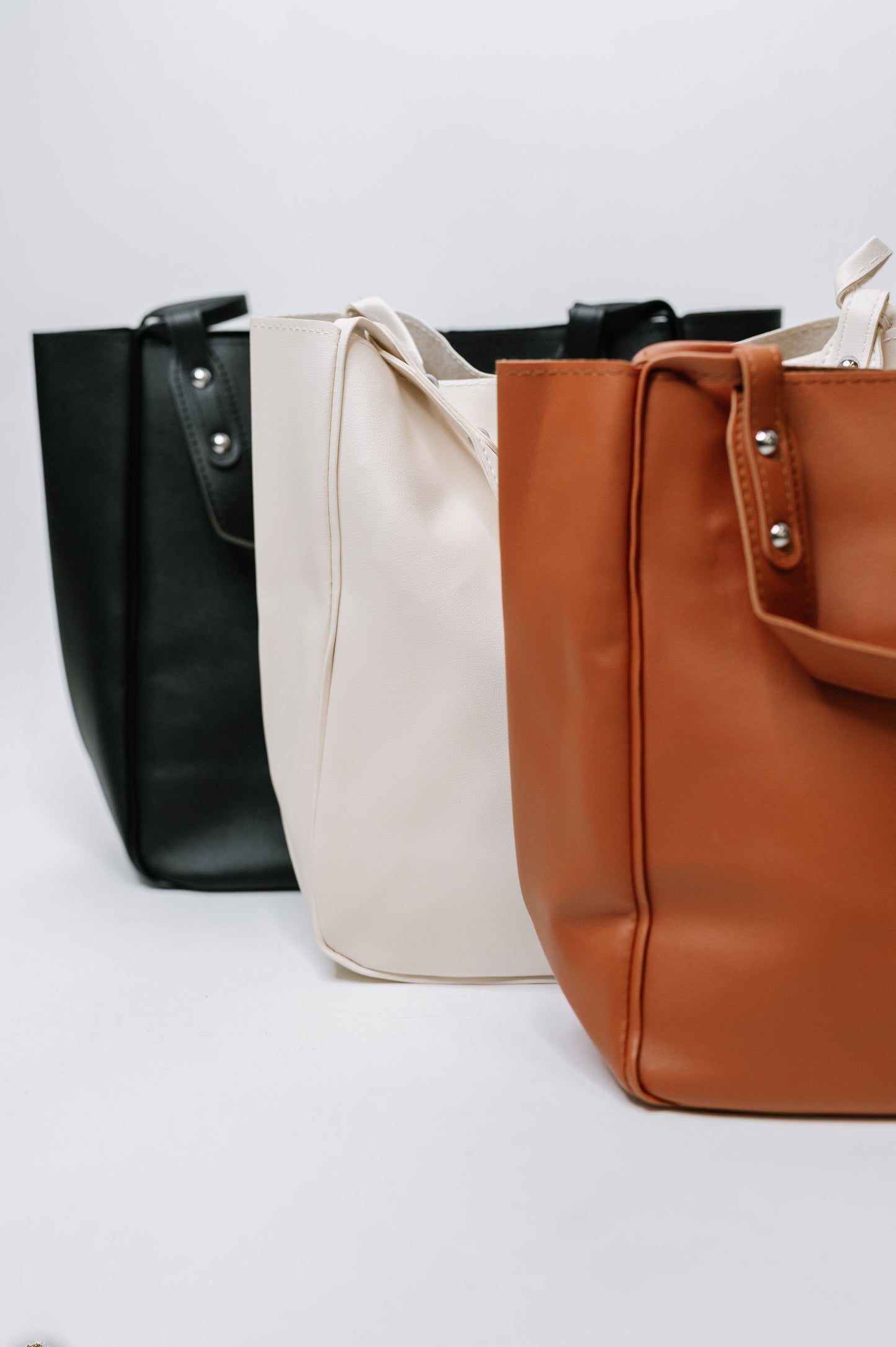 My Whole Life Shoulder Bag available in brown, black and Neutral with silver hardware and sleek faux leather finish.