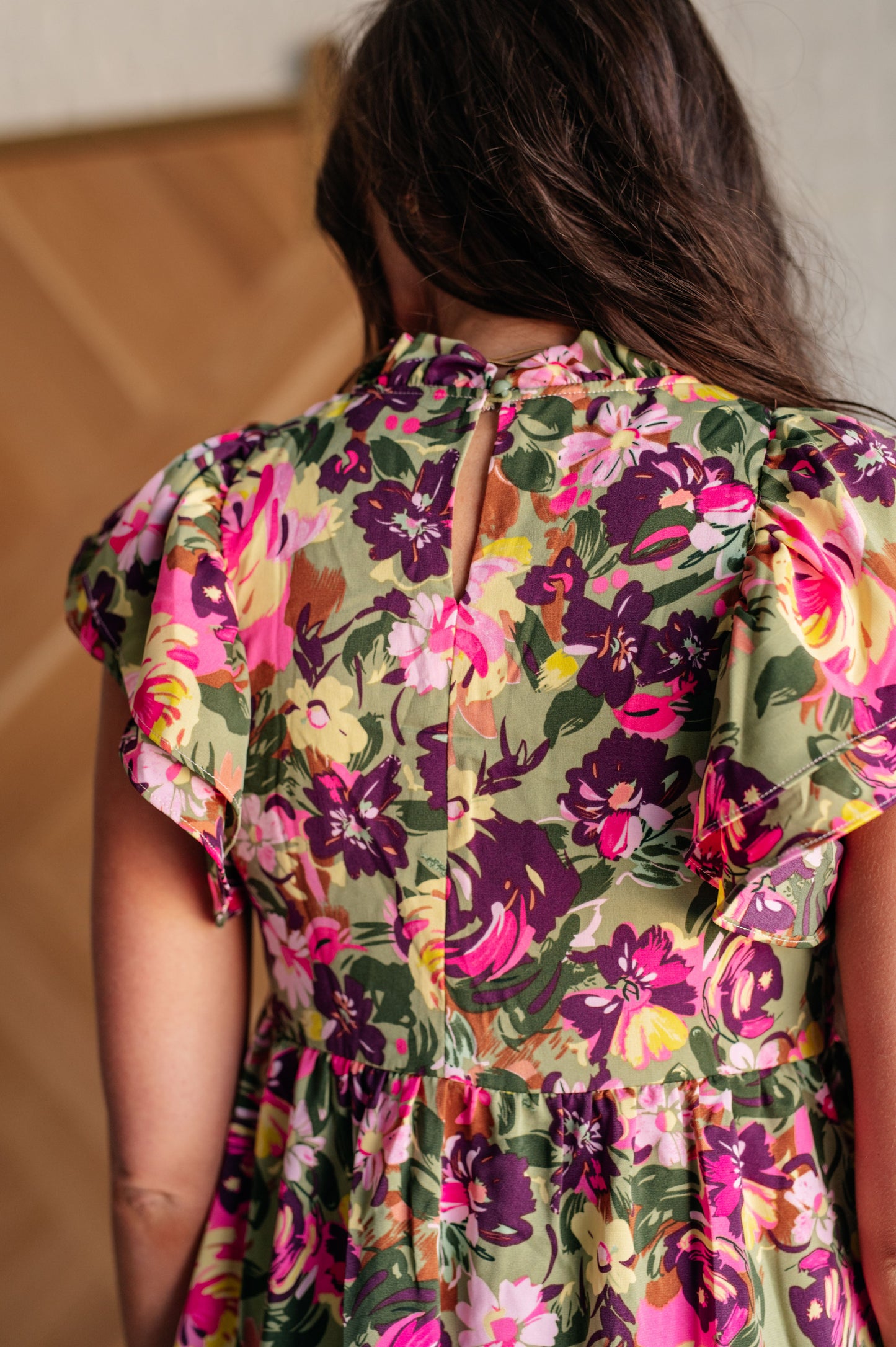Close-up of Nita Floral Dress fabric and neckline, highlighting textured floral print, ruffled mock neck, and button closure.