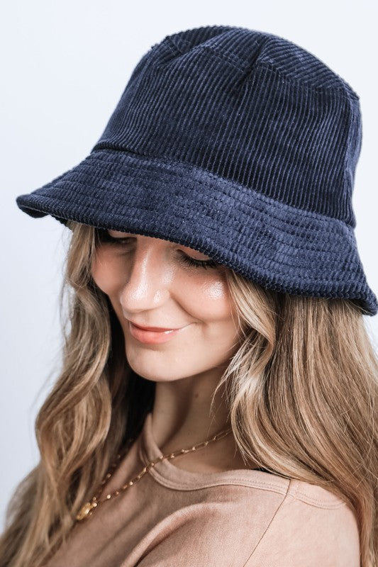 Woman pairs a navy Bennet Corduroy Bucket Hat with a laid-back look.