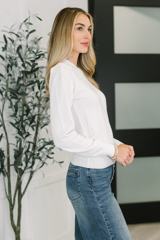 Side view of Nessy Long Sleeve Top in White highlighting slightly sheer lightweight knit.