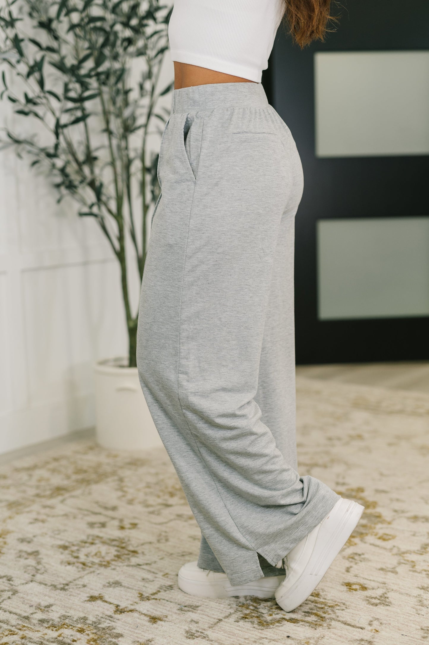 Side profile of Jara Wide Leg Pants highlighting wide leg silhouette, cased elastic waistband, and faux welt pocket detail.