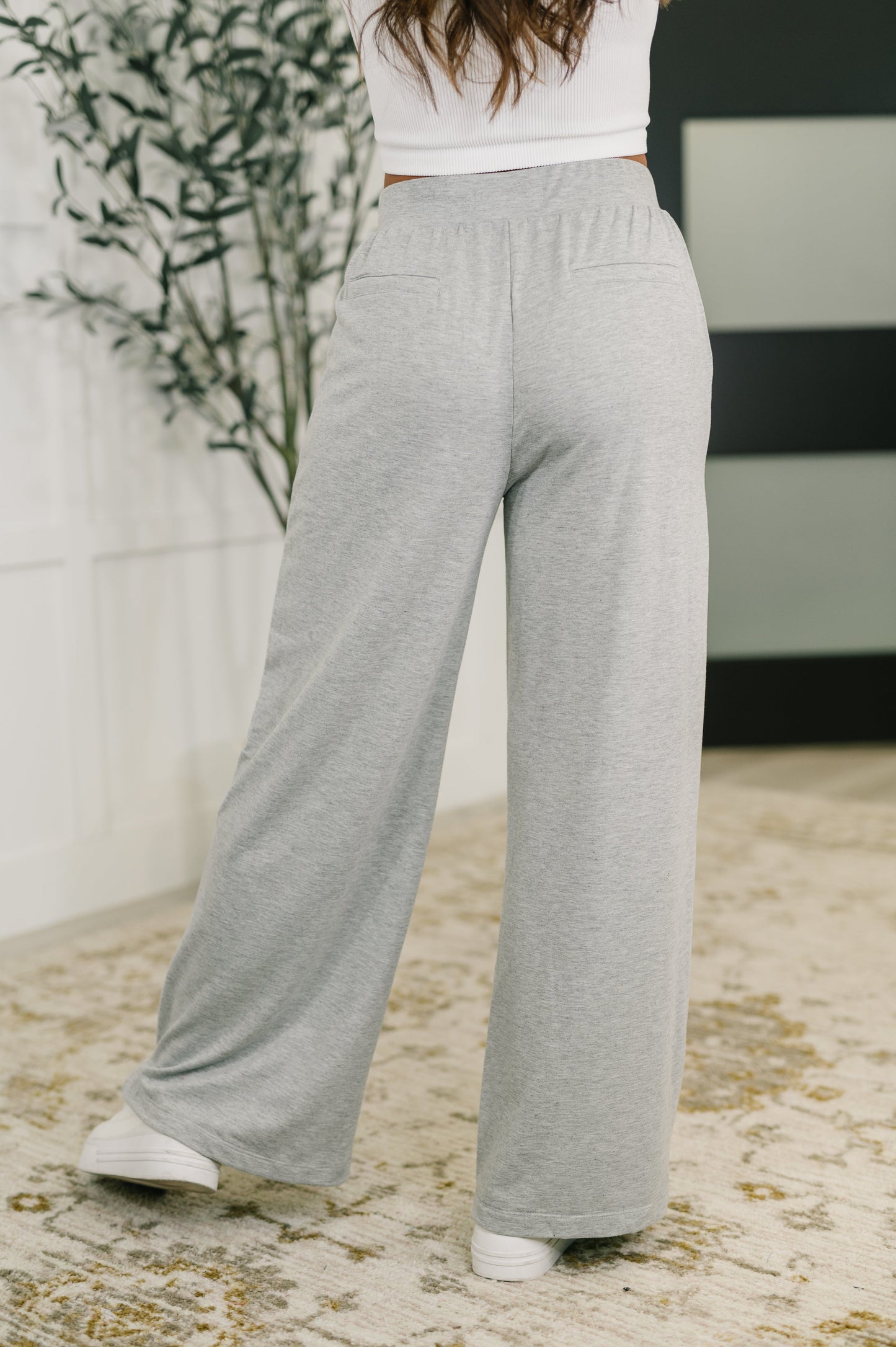 Back view of Jara Wide Leg Pants with center back seams, faux welt pockets, and relaxed wide leg drape.