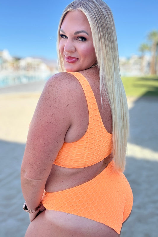 Plus size side view of Oh So Orange textured swim bottoms, cheeky fit