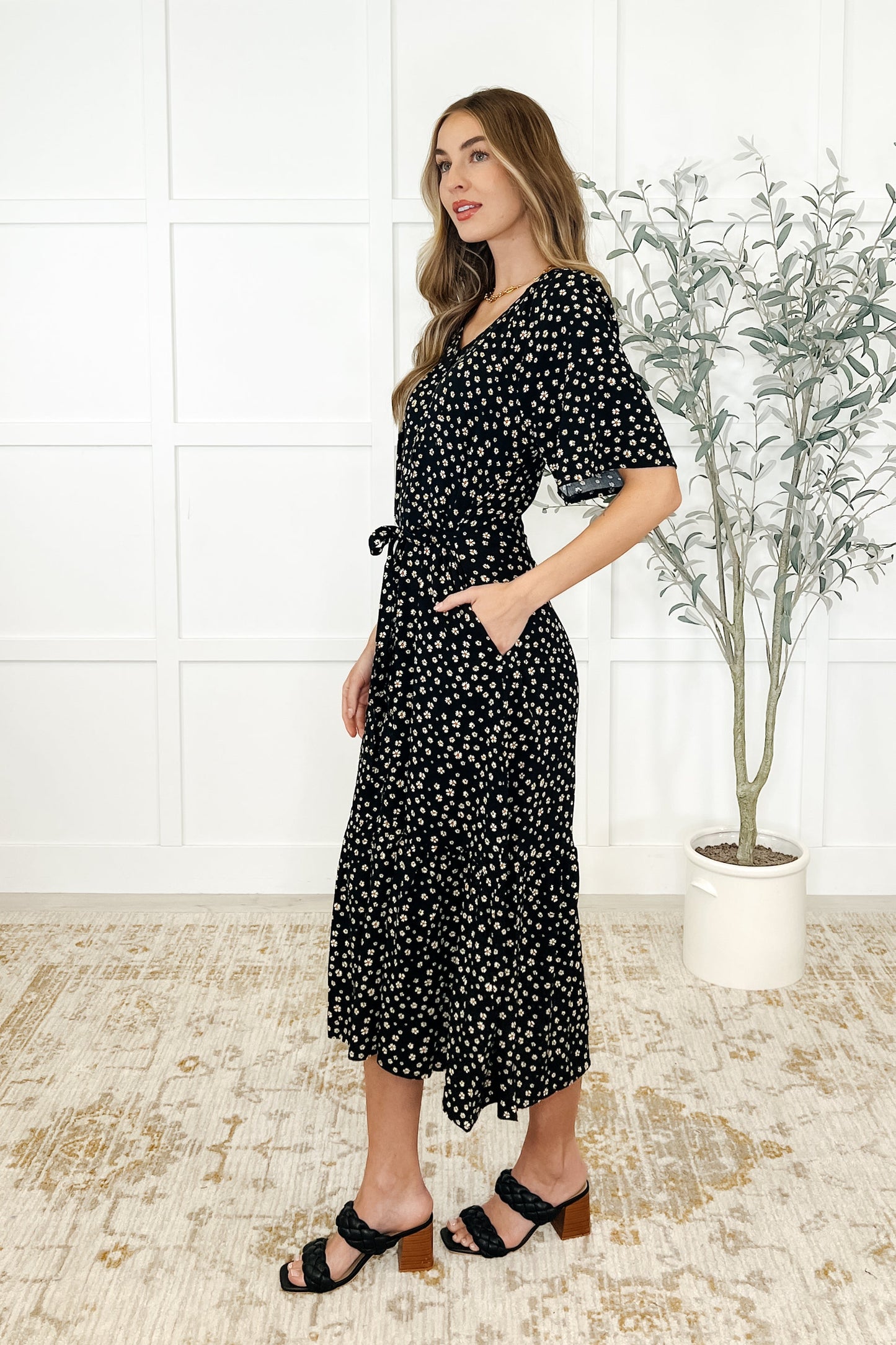 Side view of Olive Daisy Blossom Dress highlighting pockets, tiered design, and daisy floral pattern.