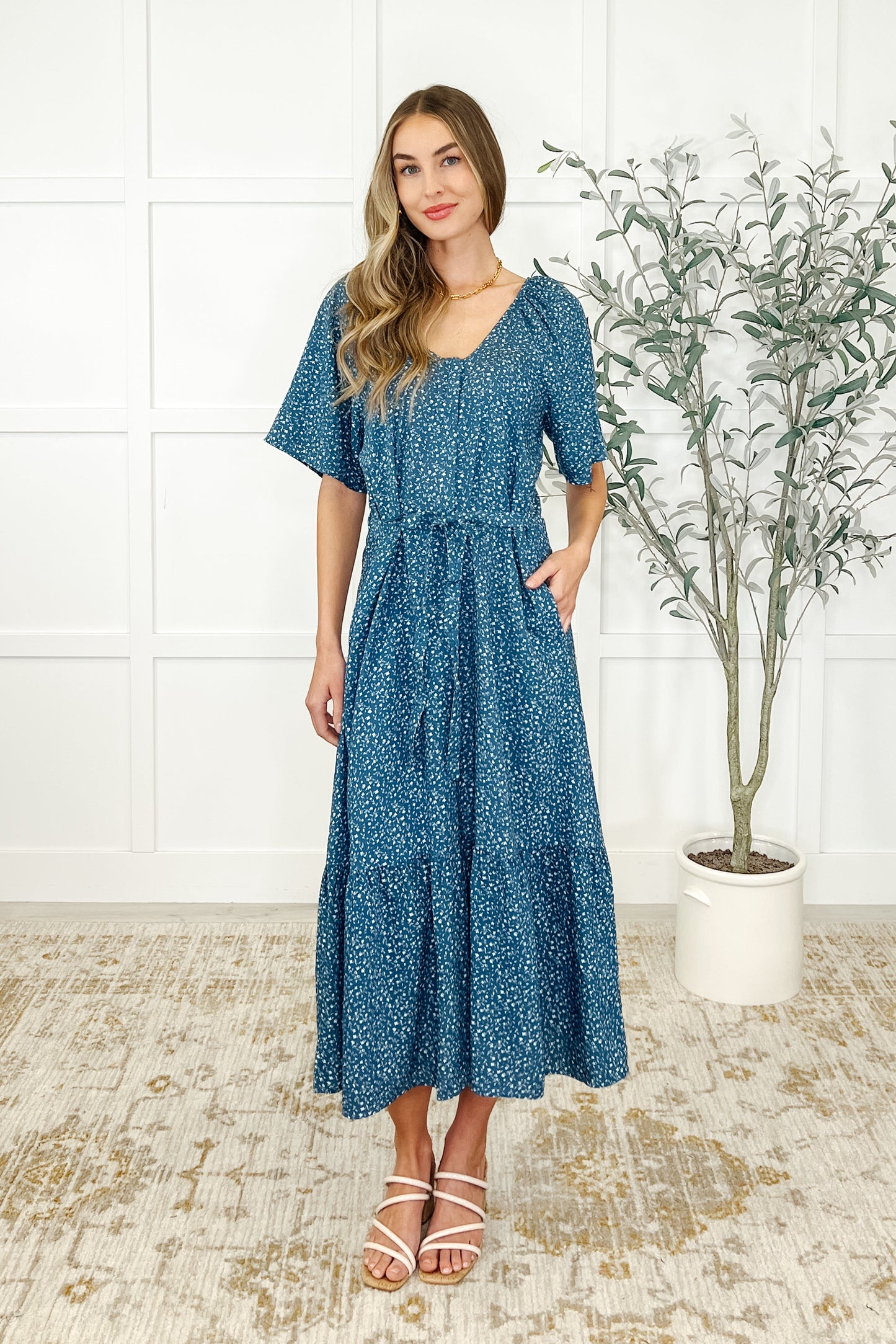 Full body view of Olive Blue Floral Dress showing lightweight fabric, flowy tiers, and side pockets.