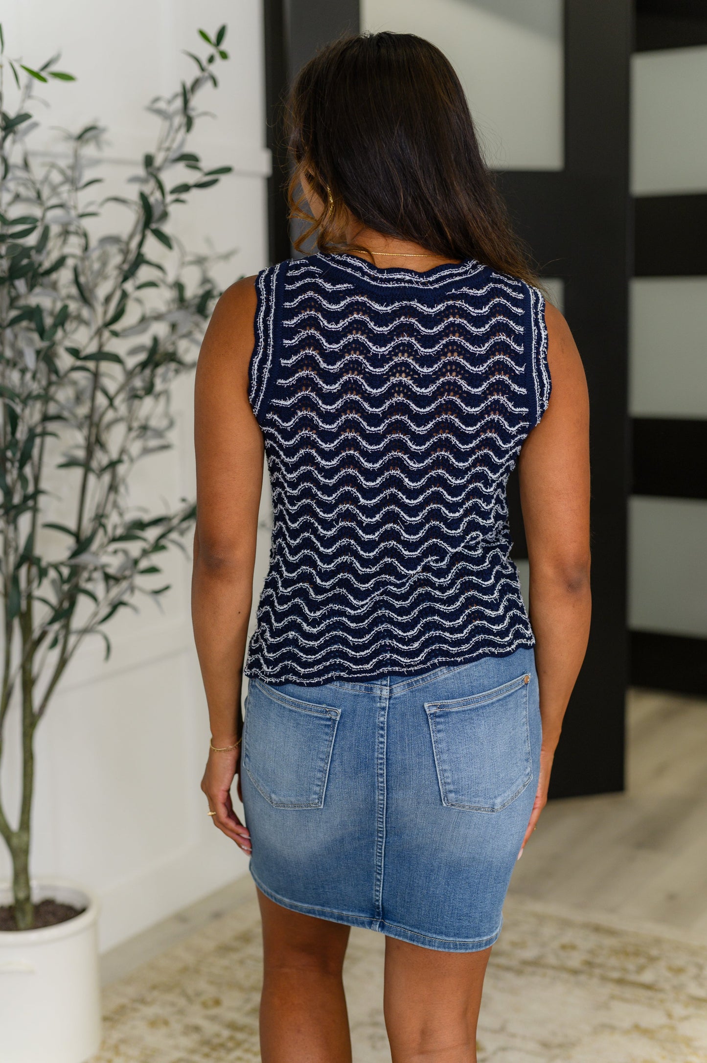 Back view of model wearing the Alena Navy Striped Tank Top, showcasing the scalloped hem and relaxed knit fit.