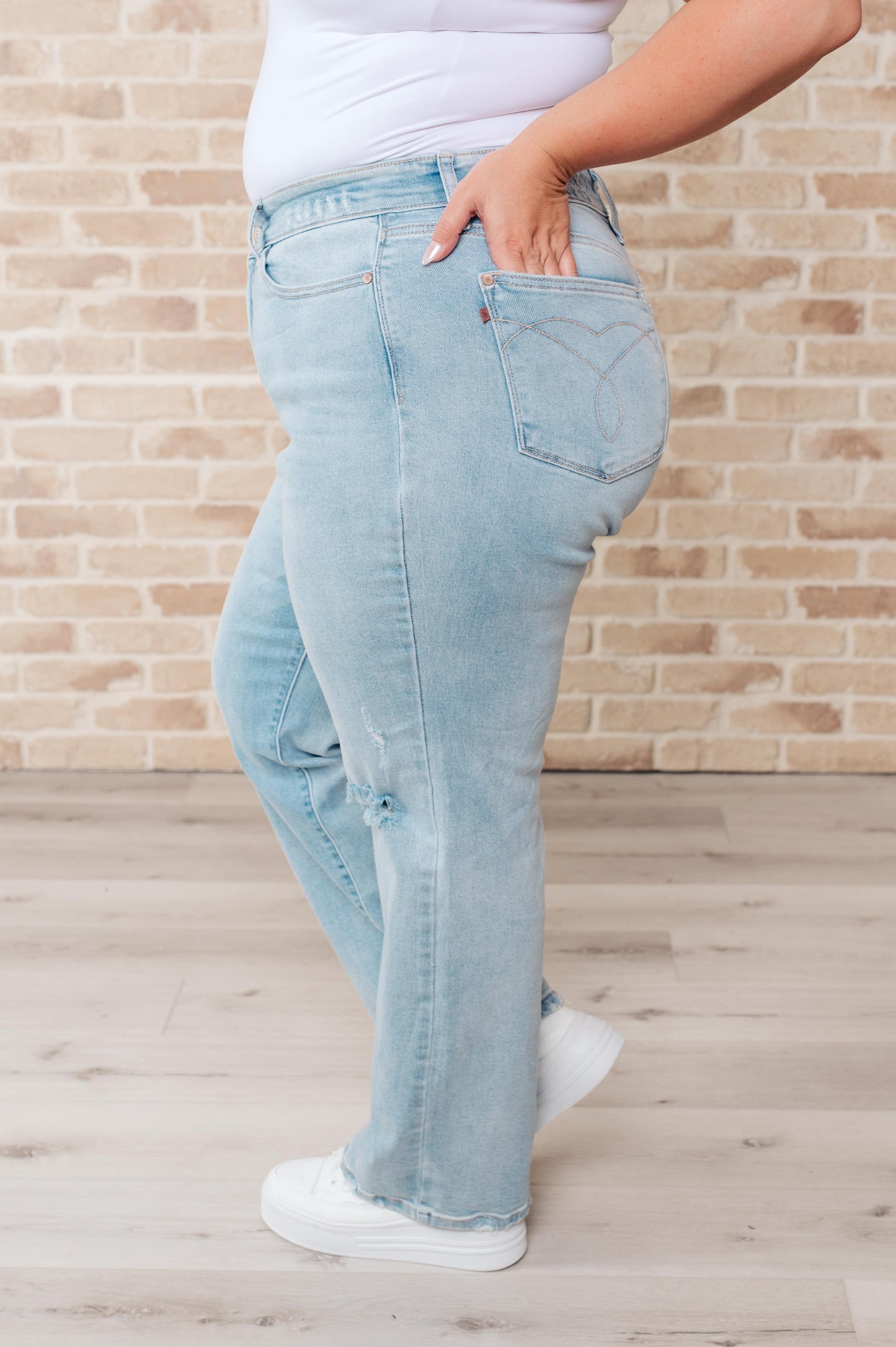 Plus size side view of Parker Straight Jeans showing light wash denim and bold distressed details.