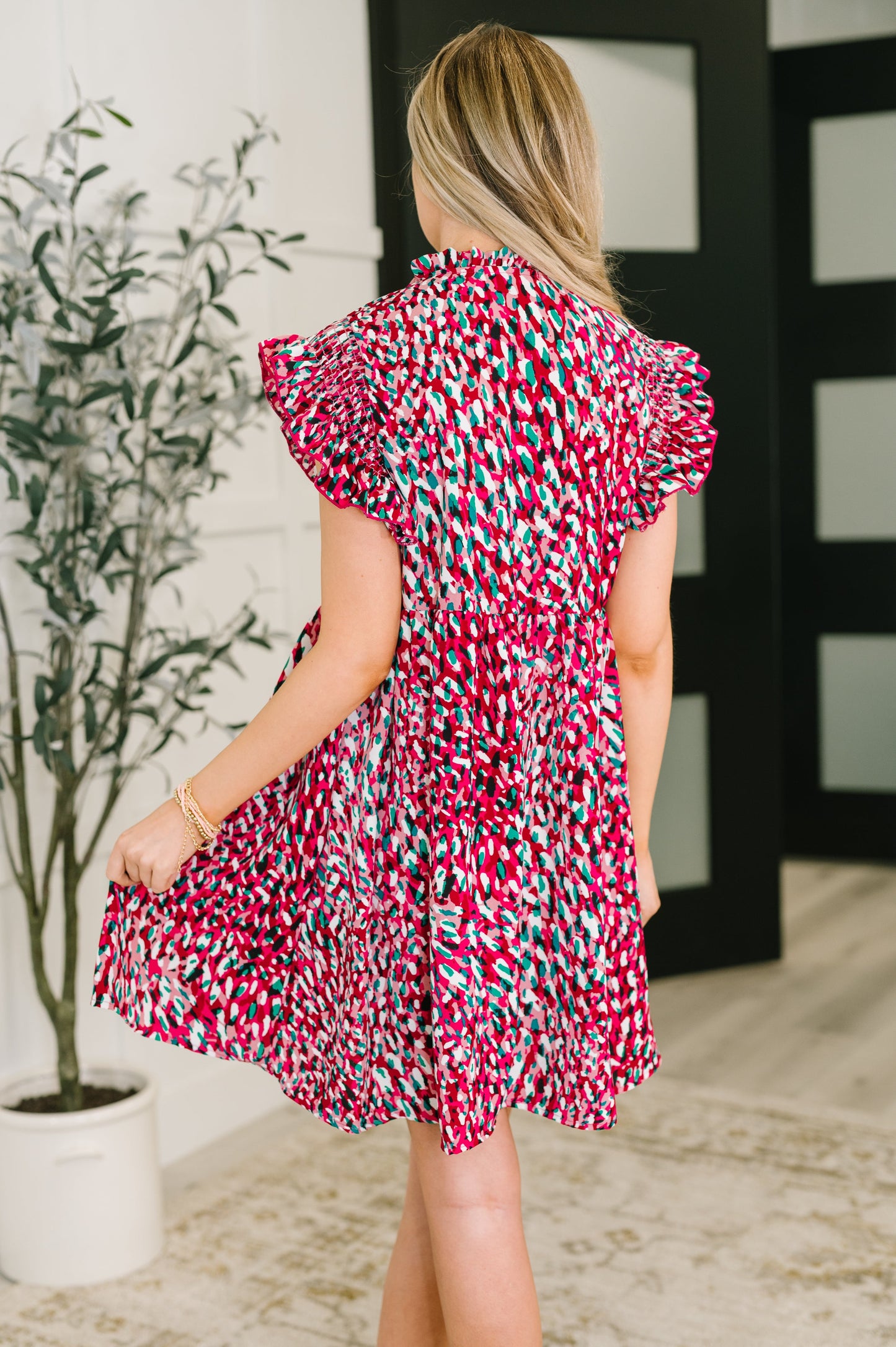 Back view of Jocelyn Bow Detail Dress in fuchsia and black, flutter sleeves visible.