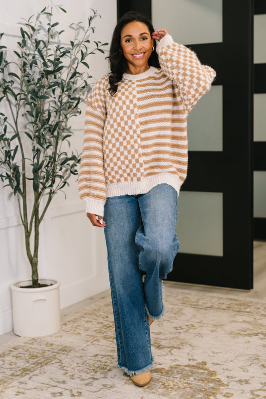 Woman wearing taupe checkered Matilda Pullover with jeans and beige boots.
