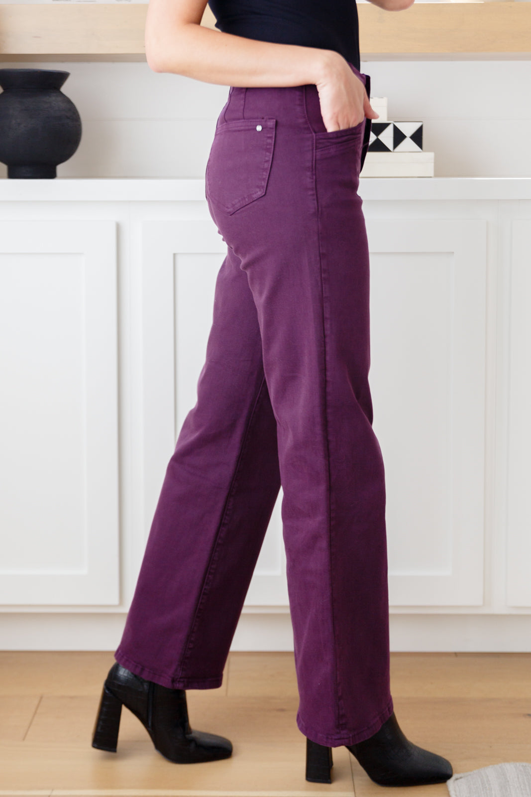 Side view of Petunia Plum Wide Leg Jeans showing contour seaming and double-button waistband.