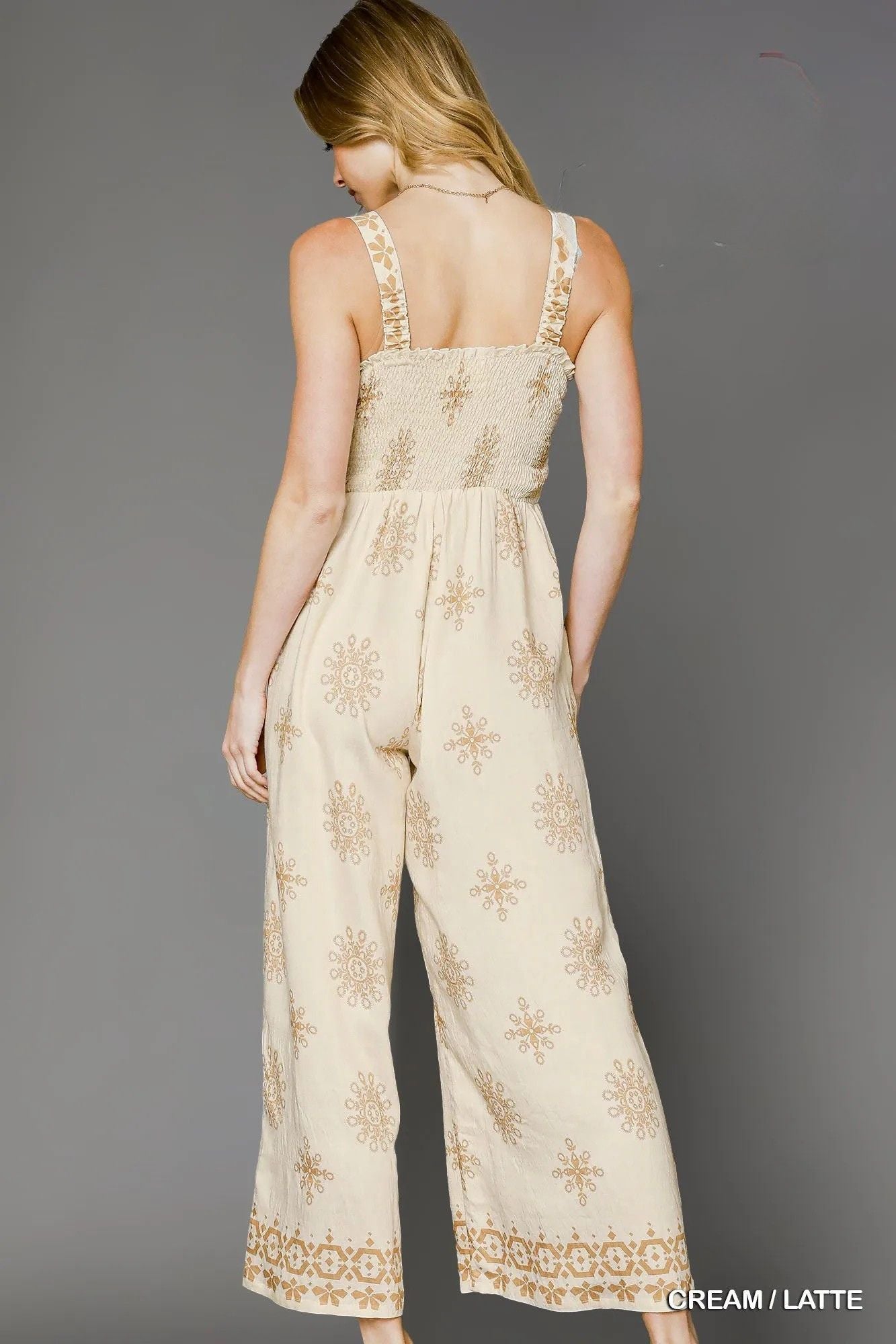 Back view of the Andie Smocked Printed Wide Leg Jumpsuit in cream, showcasing the smocked bodice, sleeveless design, and relaxed wide-leg silhouette.