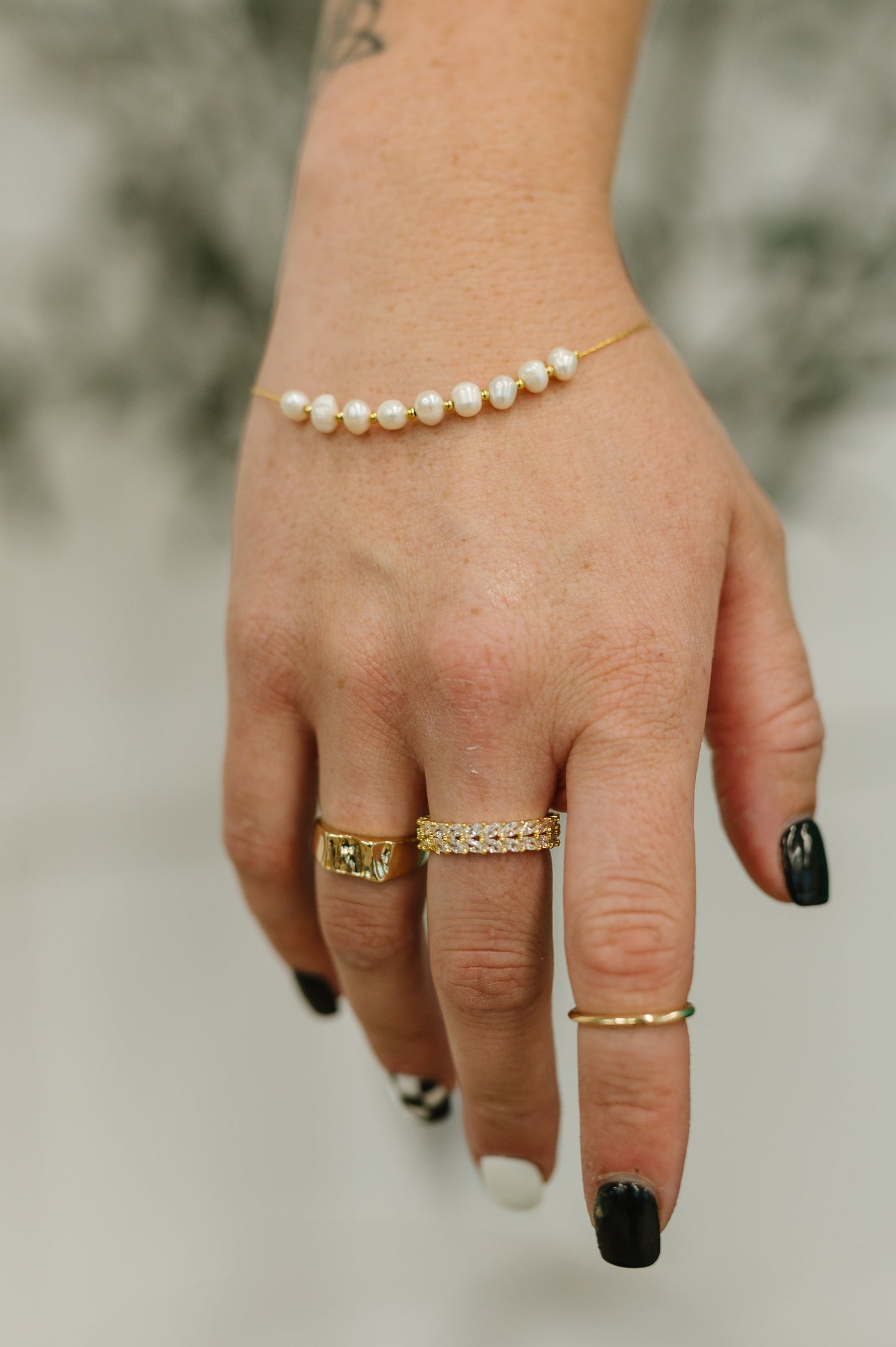 Close-up of Pretty in Pearls Bracelet on wrist, showcasing pearl beads and 18K gold chain.