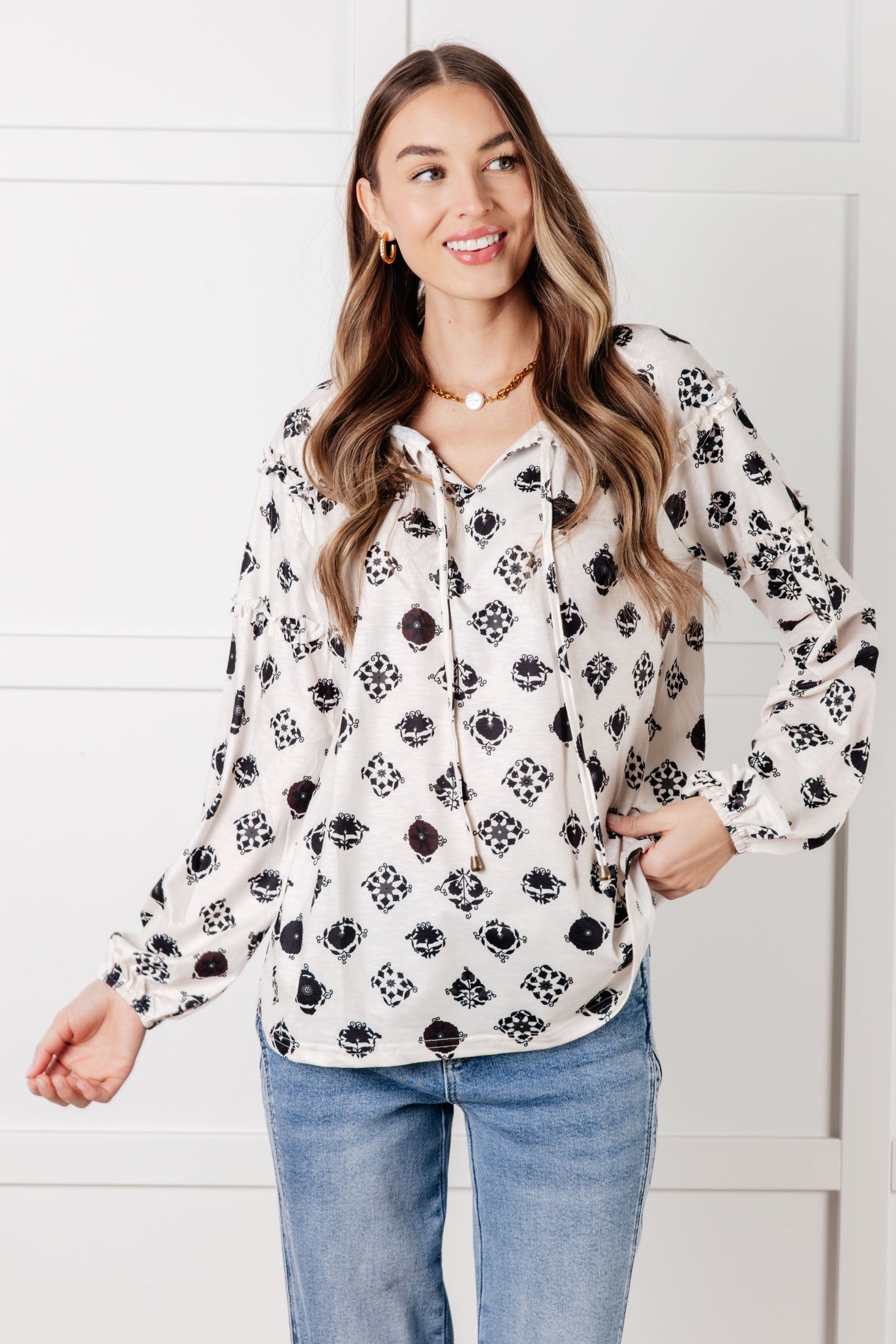Model wearing Quincy Floral Tile Blouse, close-up of floral print with tie neckline and soft ruffle details.