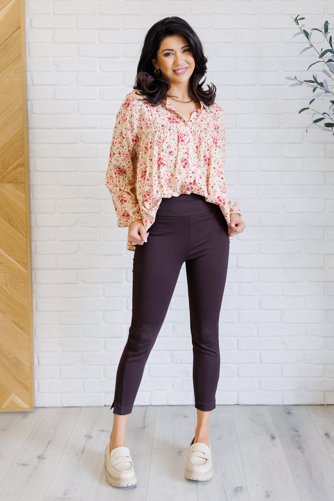 Regular model seated in Rea floral poplin button down with collared neckline and long sleeves.