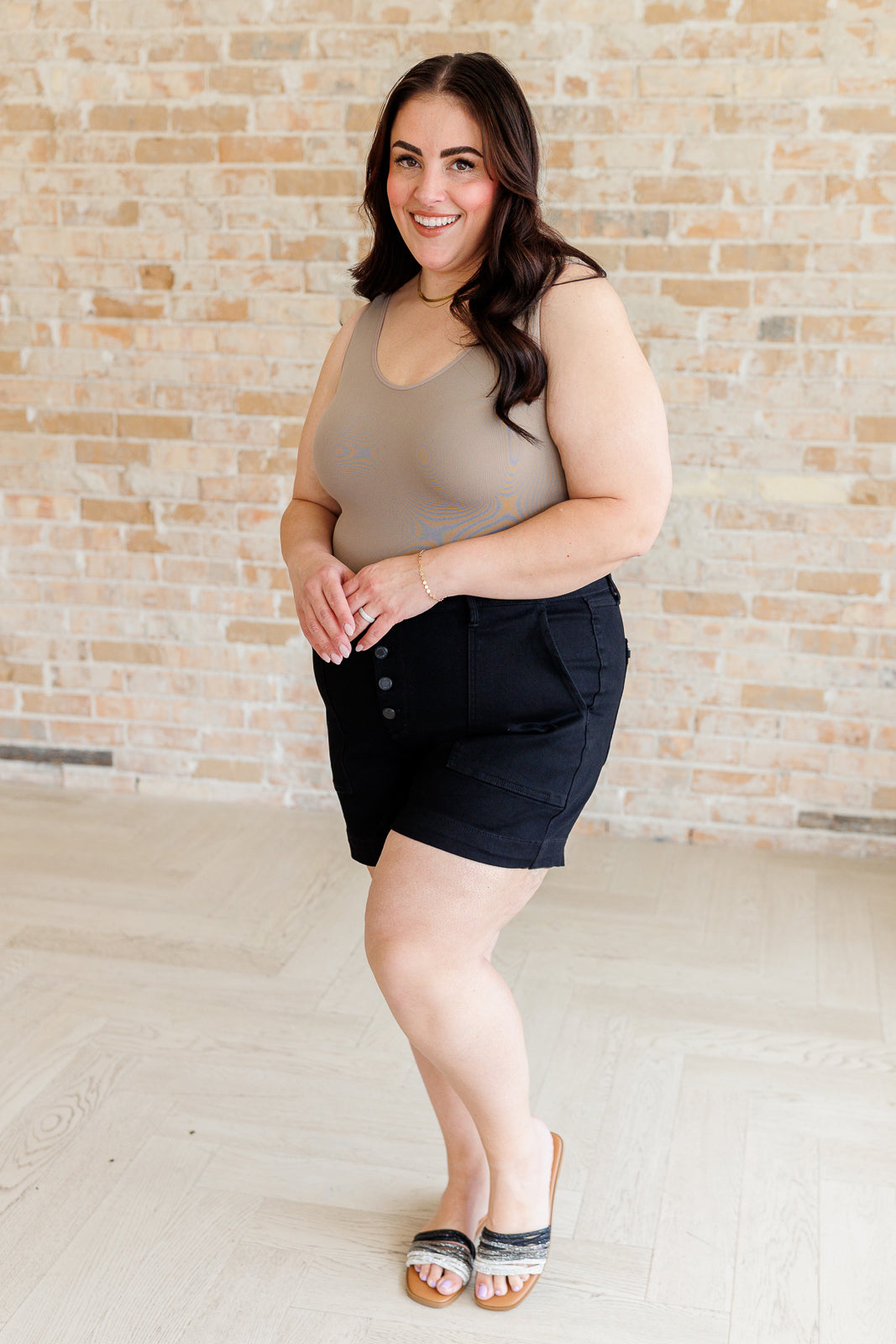 Plus size model full body view of Reagan High Rise Trouser Shorts in black denim with clean non-distressed design.