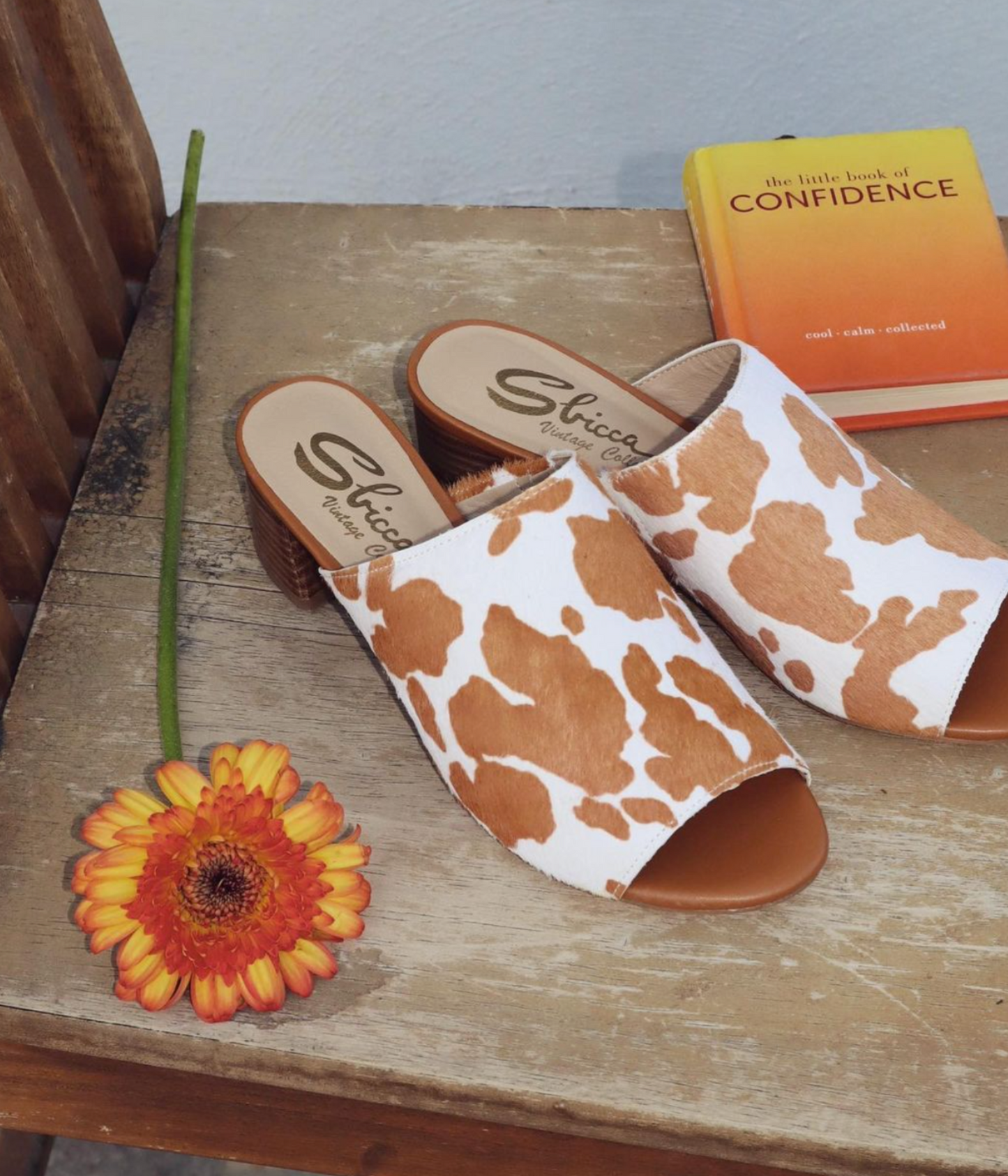Front angle view of Prairie Tan Cowhide Slides highlighting bold cowhide calf-hair print and sturdy stacked heel.