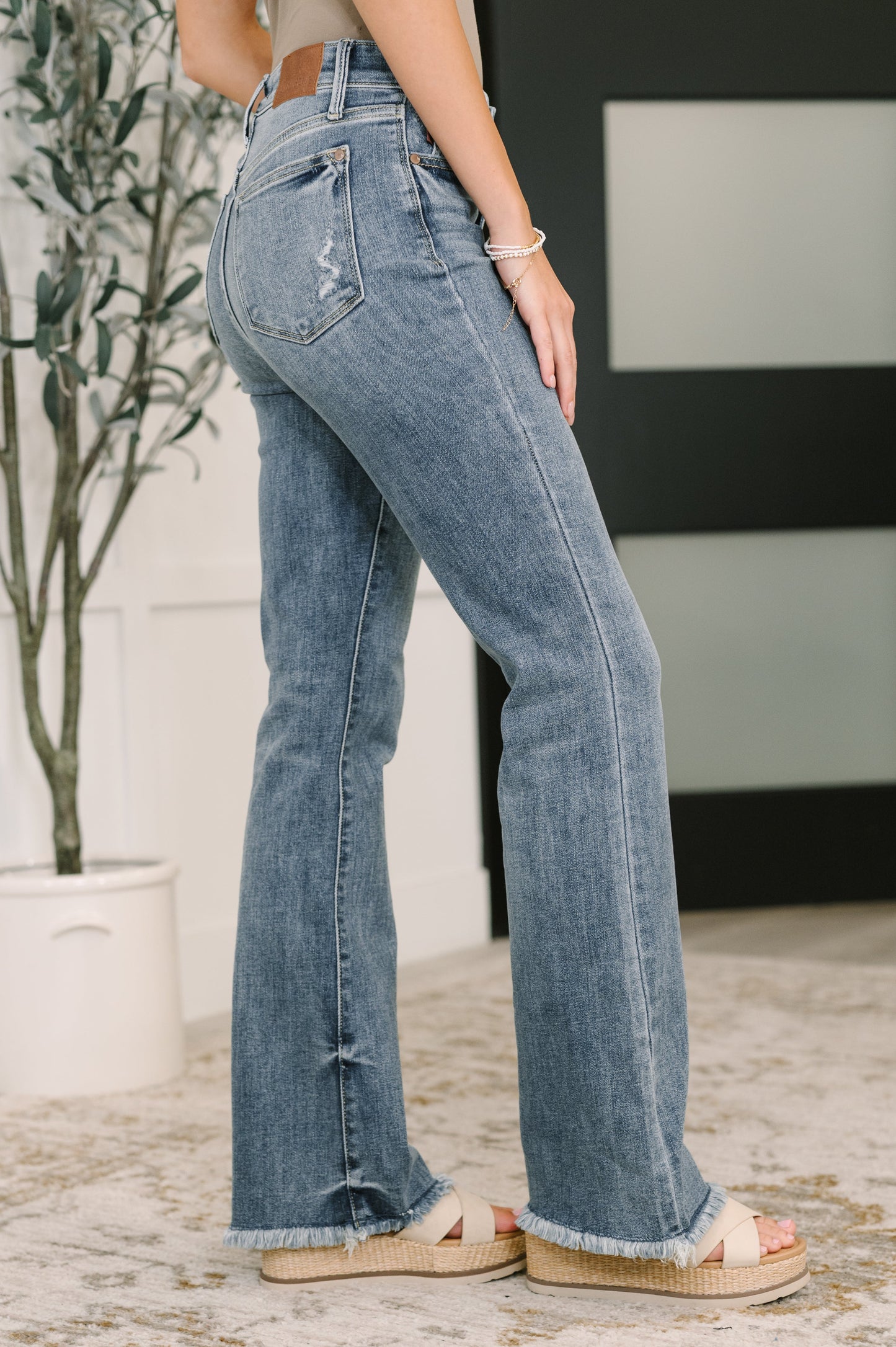 Robin High Waist Bootcut Jeans side angle showing bootcut fit and frayed hem.