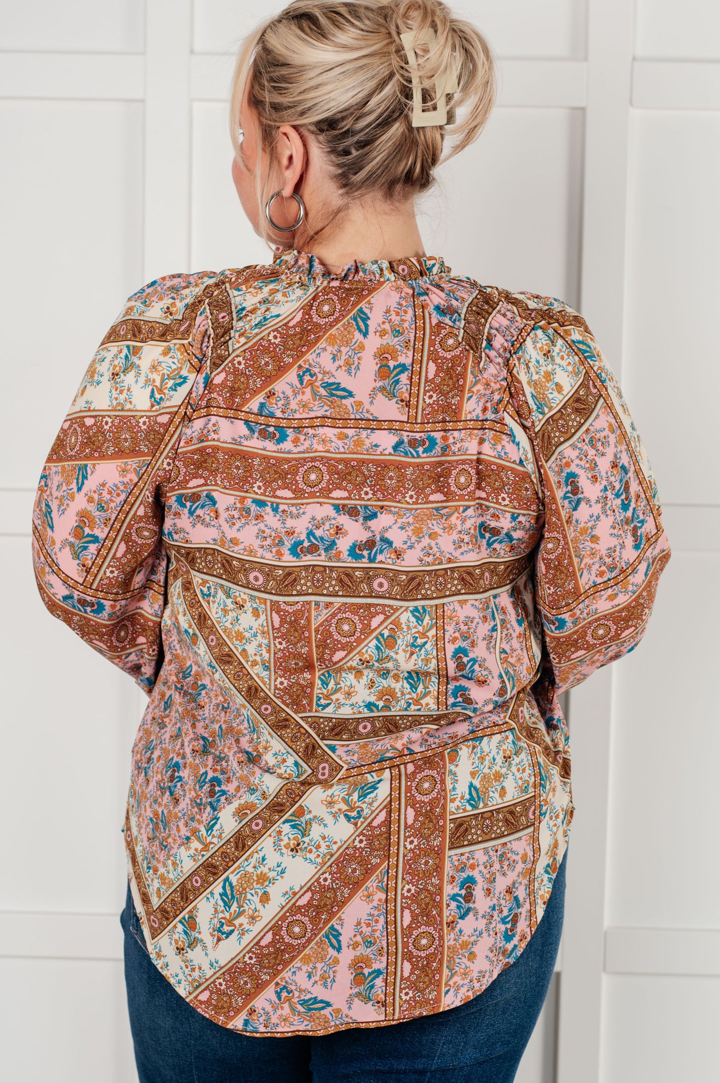 Plus-size model showing back of Elise Mixed Print Peasant Blouse with relaxed fit.