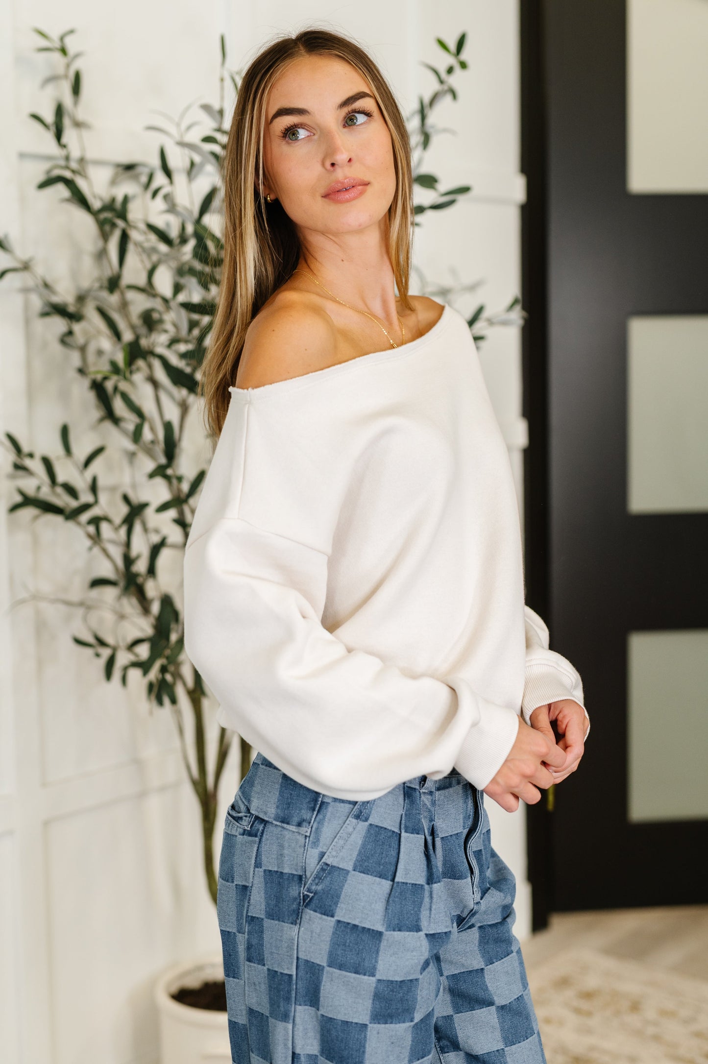 Side view of the Marlowe Off Shoulder Top in Bone showing the relaxed fit, drop shoulder, and raw neckline.