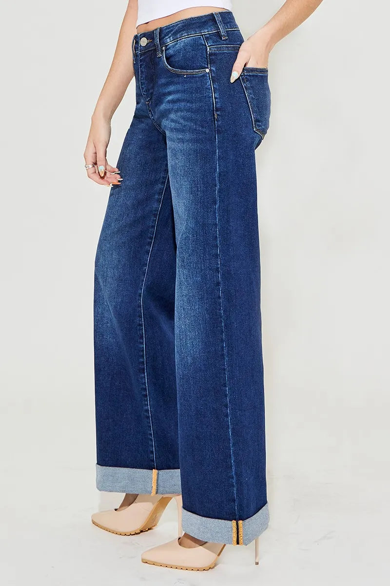 Side angle of Christina Wide Leg Jeans showing wide leg fit, dark wash, and rolled cuff detail.