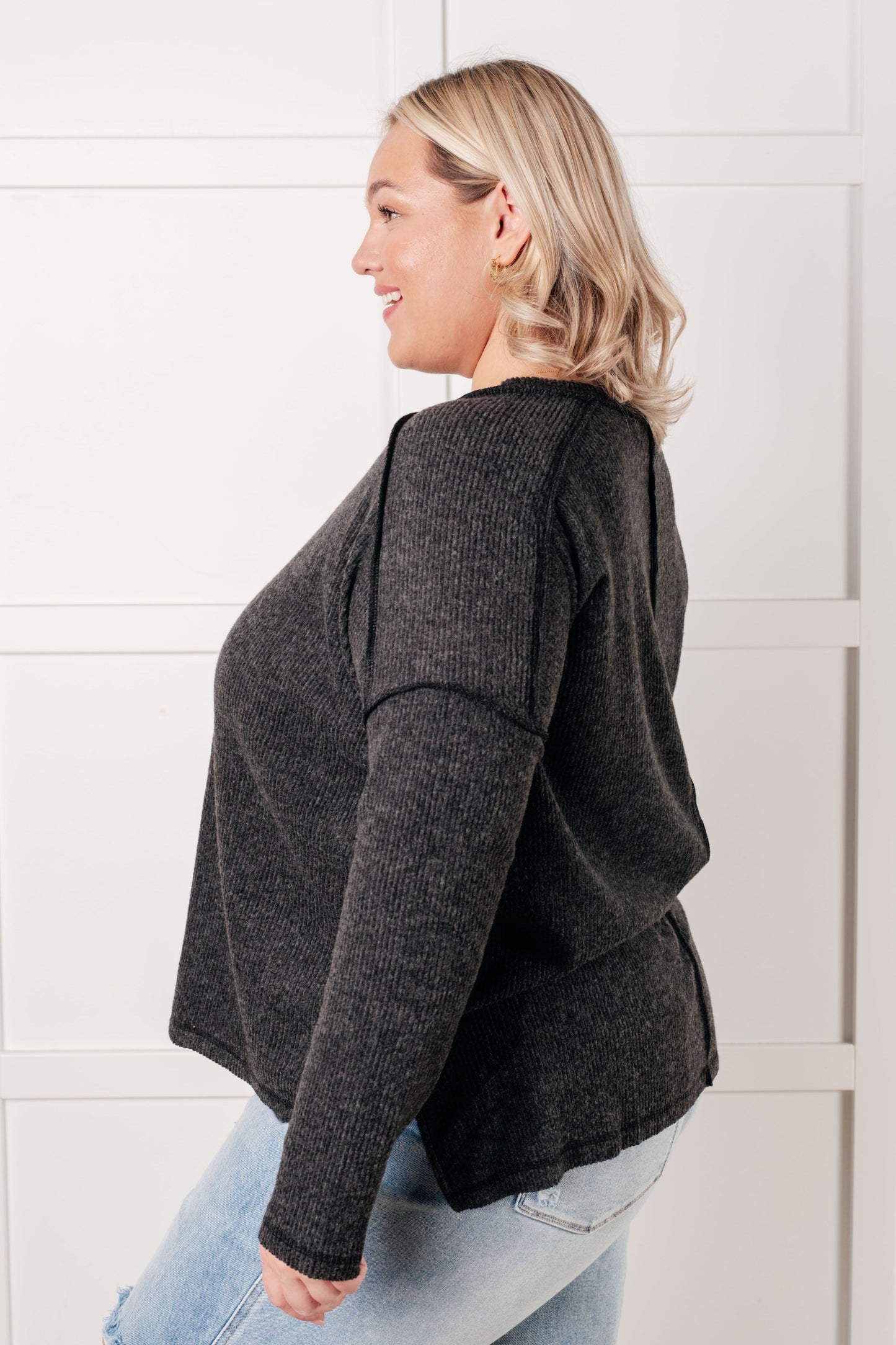 Side view plus size Simon Ribbed Hacci Sweater black ribbed knit with exposed seam and slit details.