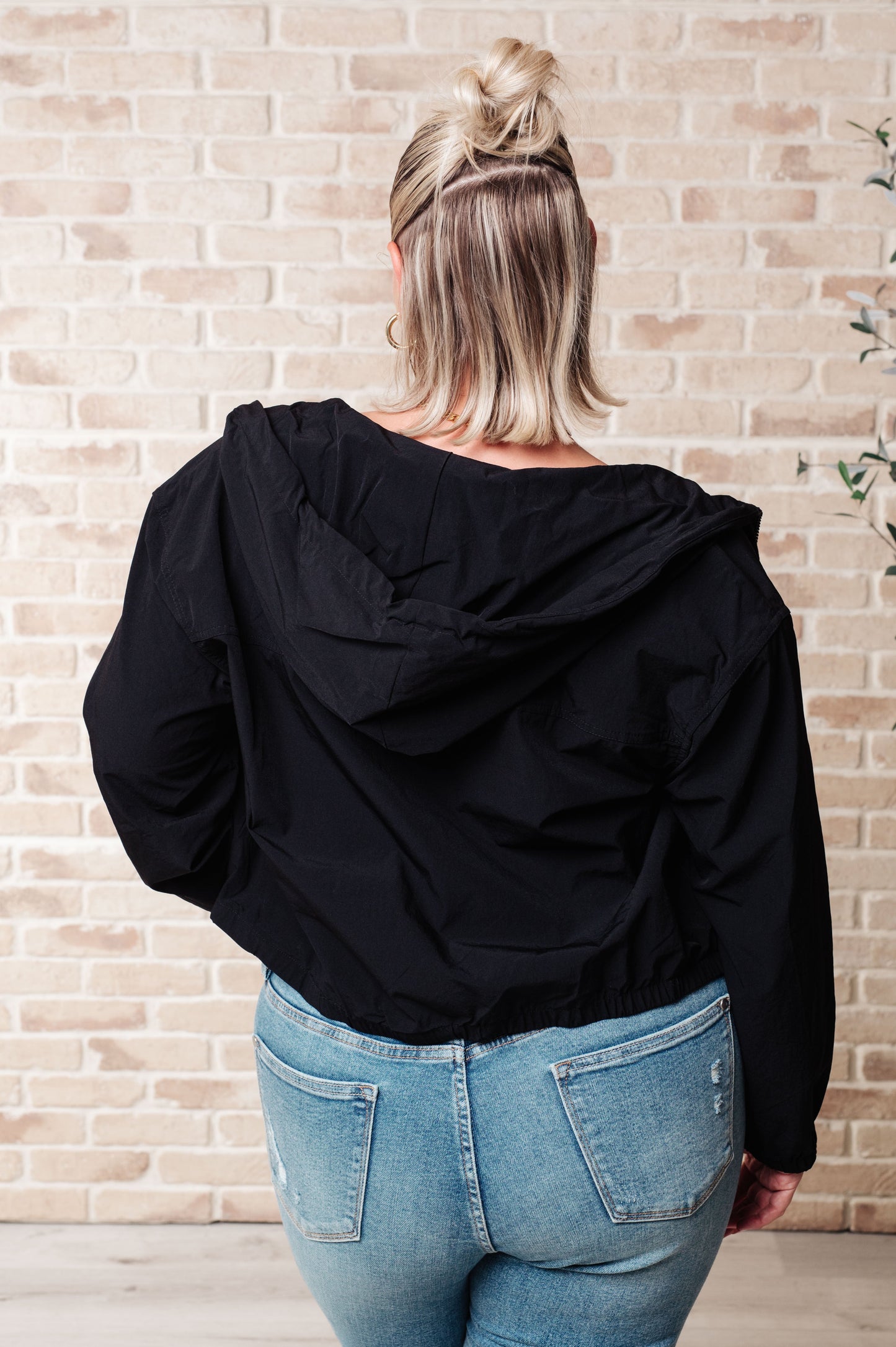 Back view of plus size Sky Zip Up in Black showing lightweight windbreaker material.