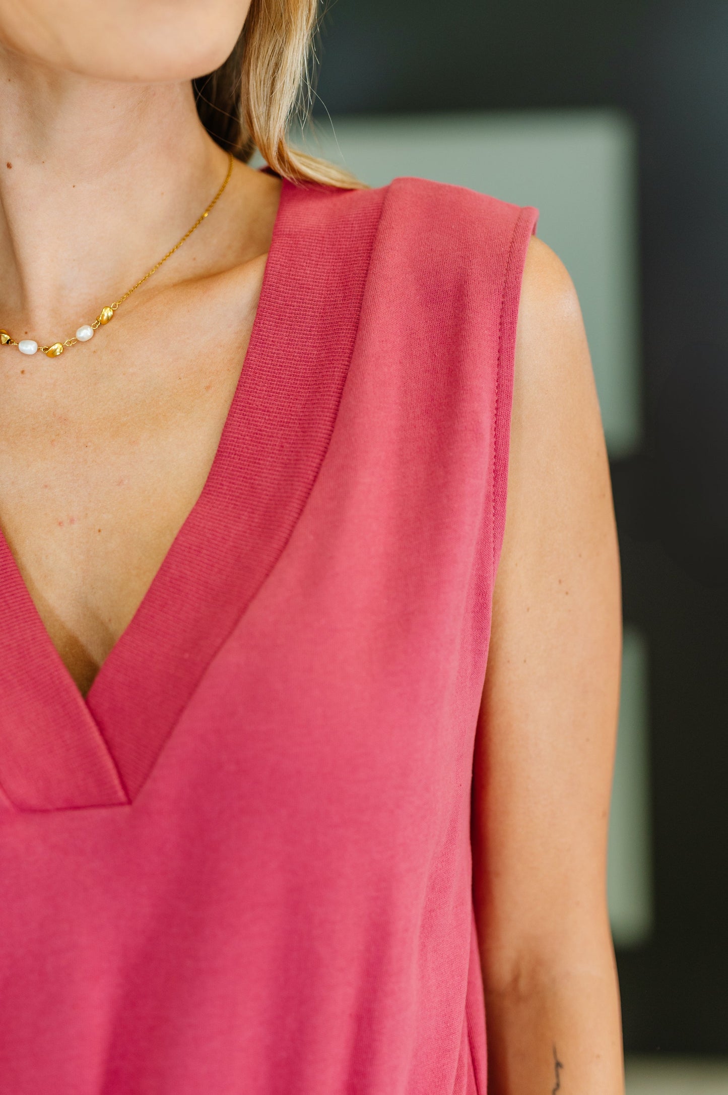 Close-up of the Lola Sleeveless V-Neck Romper in rose pink, highlighting the V-neckline, shoulder seam, and soft cotton fabric texture.