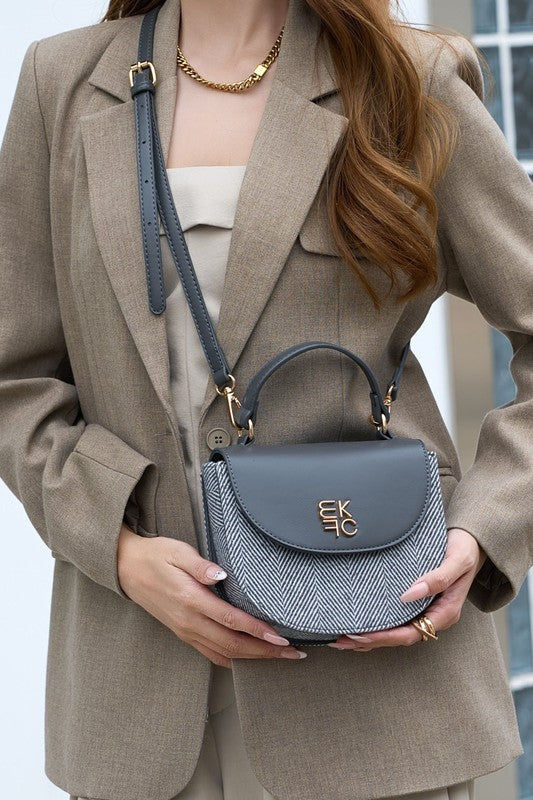 Woman wearing gray Heloise herringbone crossbody bag in crossbody style.