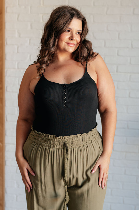 Plus size model in Saylor Black Ribbed Knit Bodysuit showing ribbed texture and square neckline.