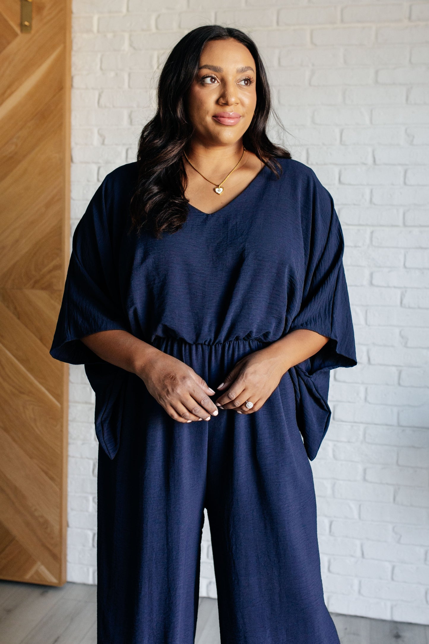 Plus size front view of Sonya Wide Leg Navy Jumpsuit with short sleeves and functional side pockets.