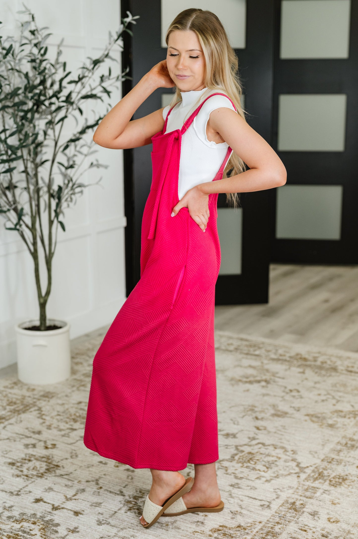 Side view of Lottie Pink Jumpsuit in quilted knit with wide-leg cut, side pockets, and adjustable tie straps.
