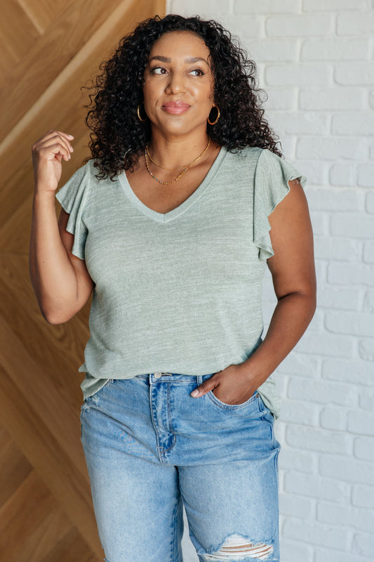 Plus size model front view wearing Teresa Flutter Sleeve Top in sage, relaxed fit with flutter sleeves
