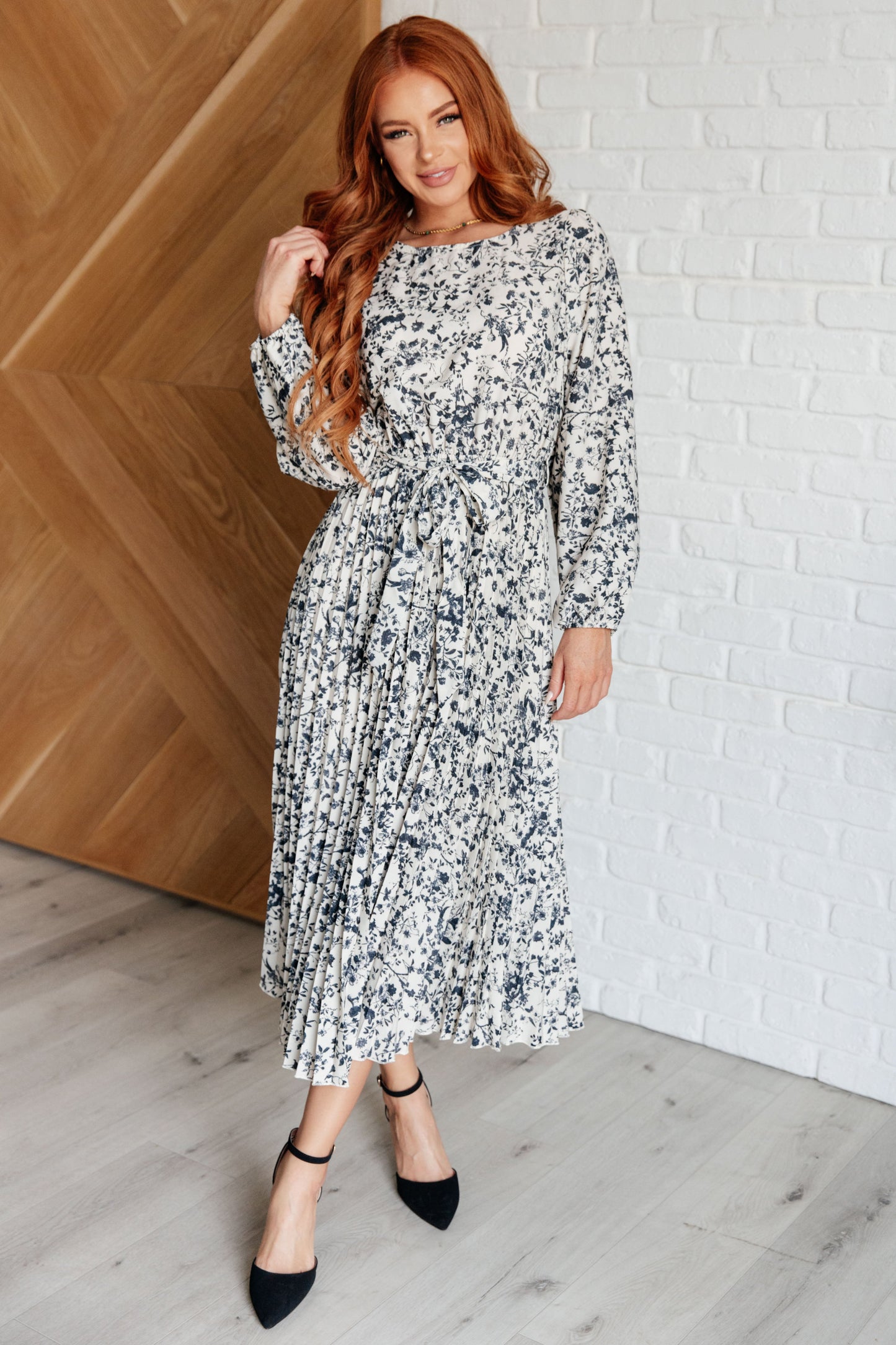 Model front view of Georgia Pleated Dress showing balloon sleeves and flowy pleated hem.