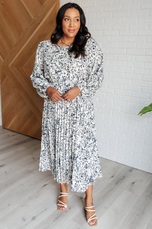 Plus-size model front view of Georgia Pleated Dress with self-tie belt and pleated skirt.