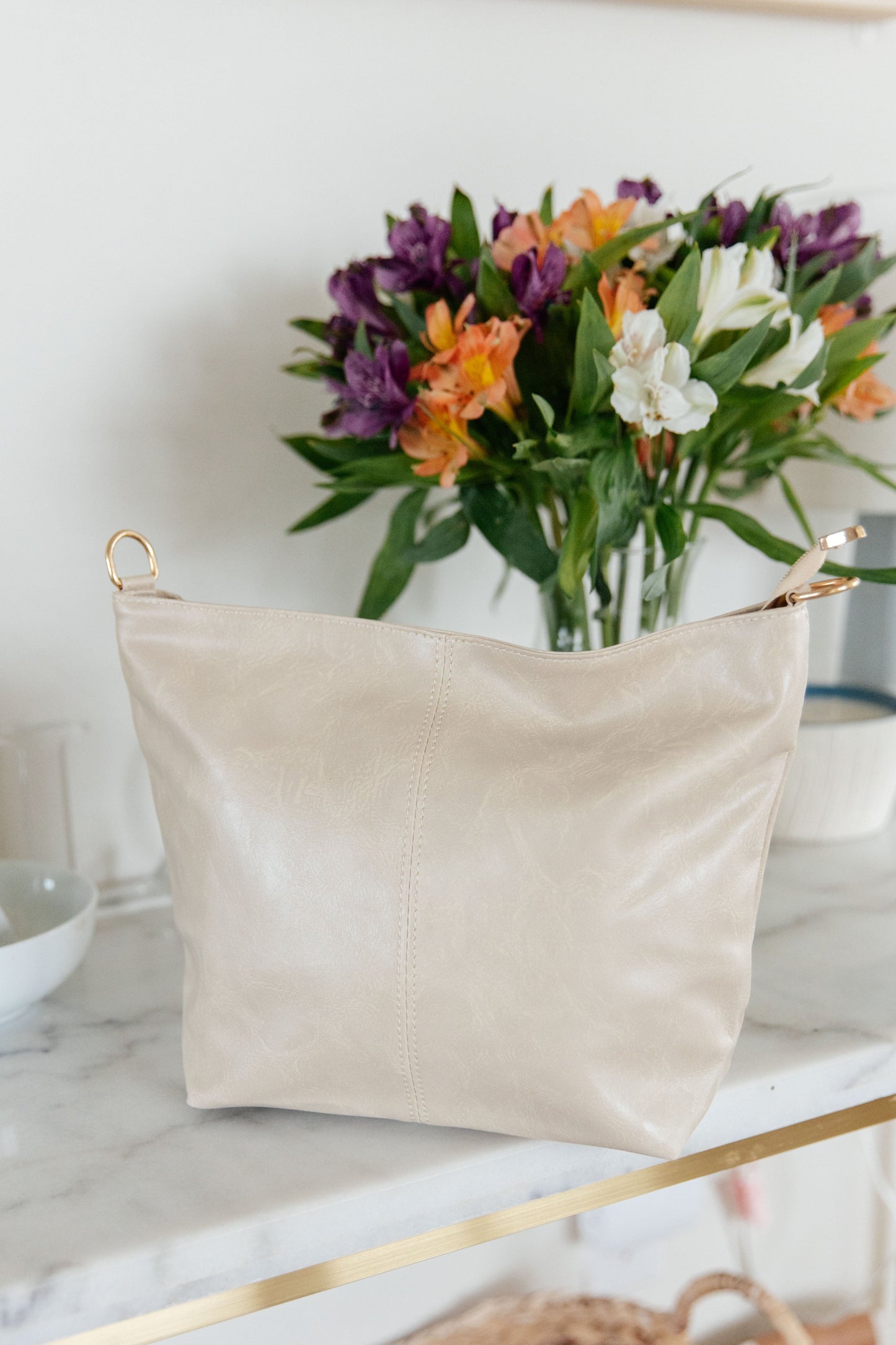 White tote with adjustable strap and zipper closure.