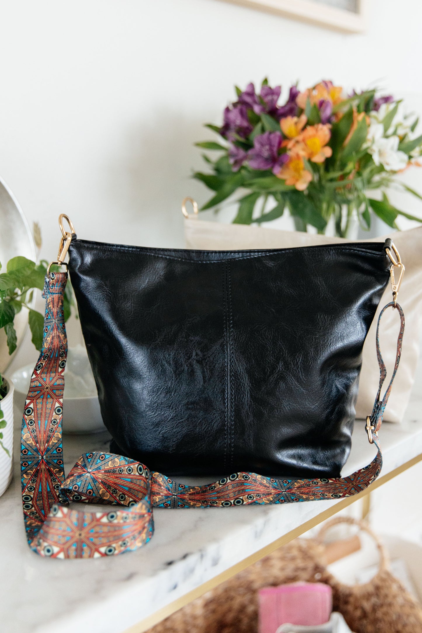 Black tote with adjustable strap and zipper closure.