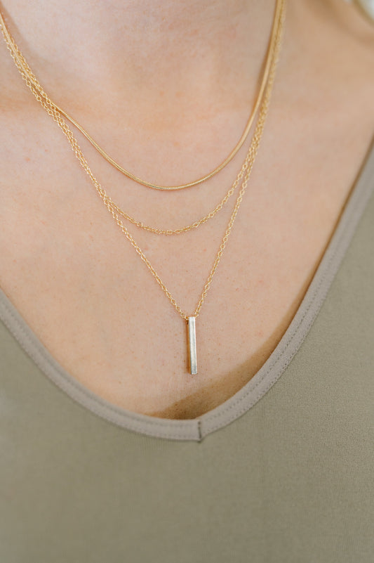 Woman wearing Signature Gold Layered Necklace with bar pendant