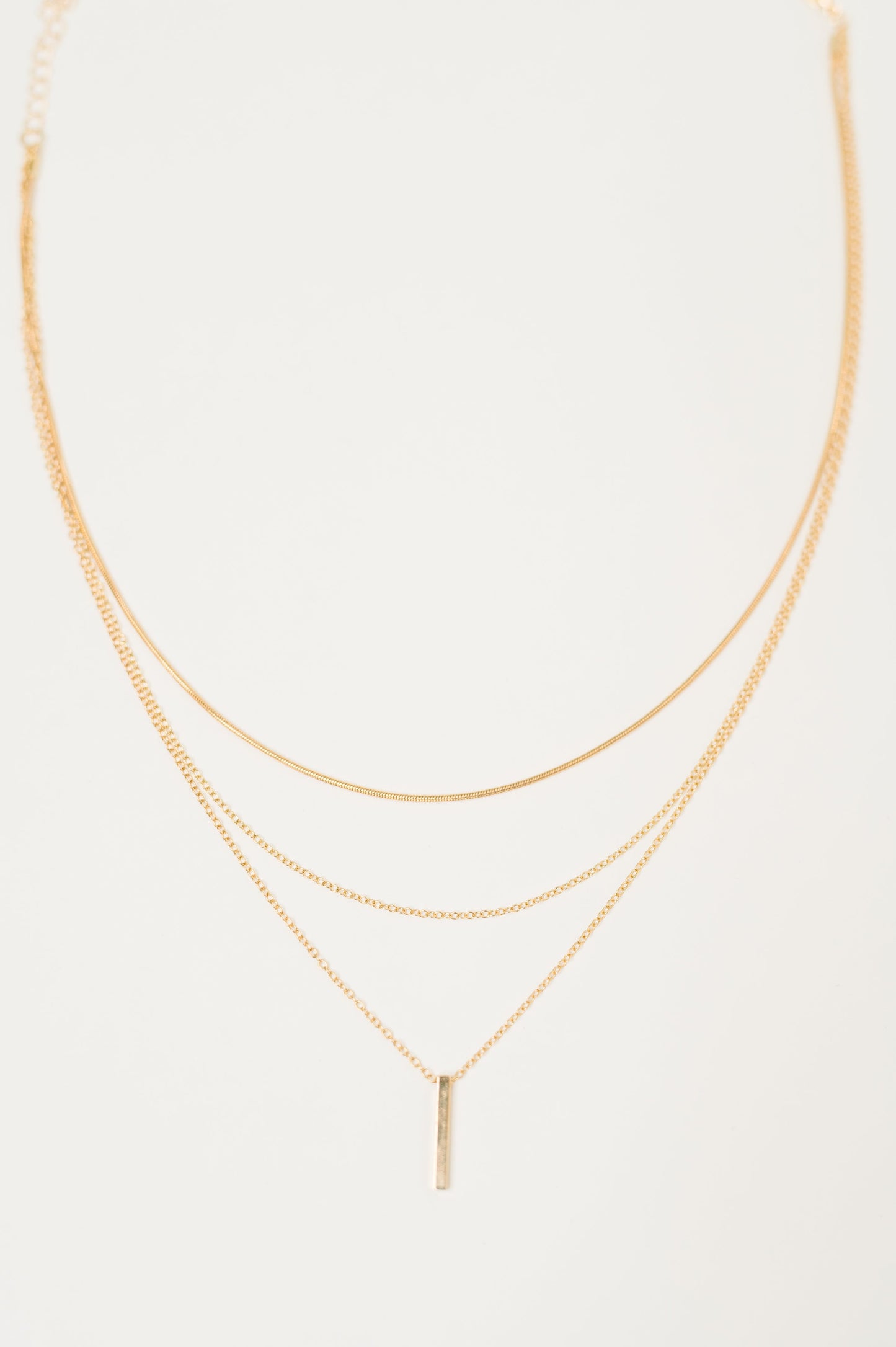 Flat lay of Signature Gold Layered Necklace with bar pendant