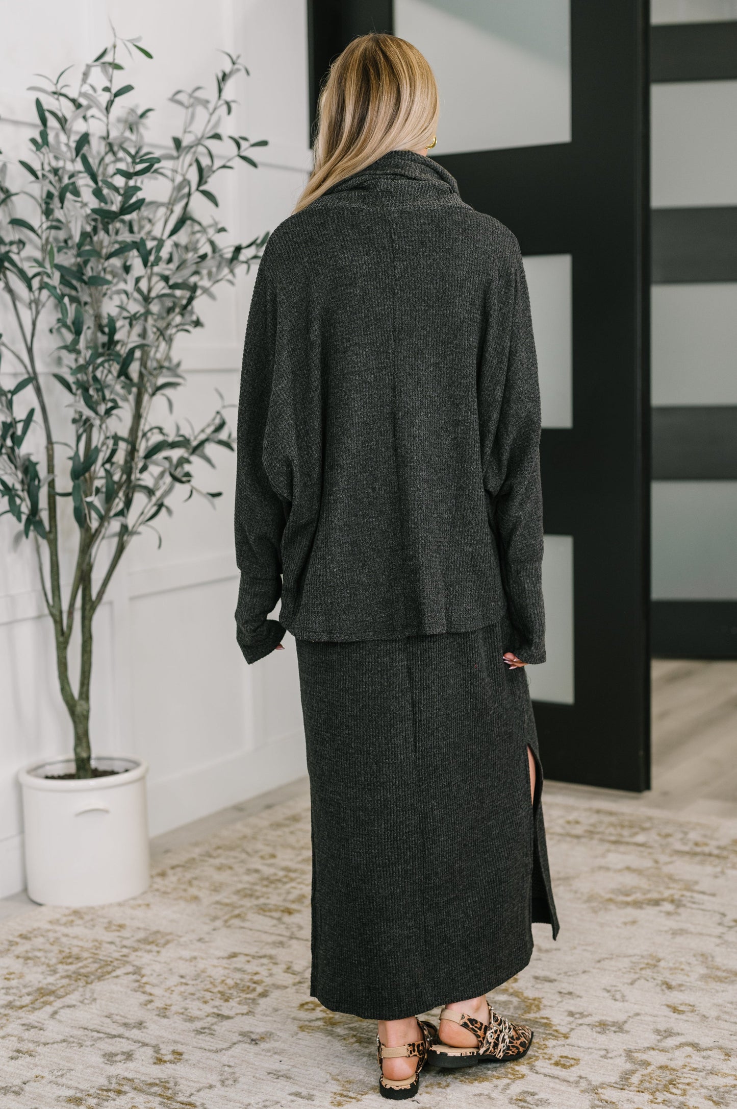 Back view of Wannetta Set in Black with textured waffle knit and exaggerated sleeve cuffs.