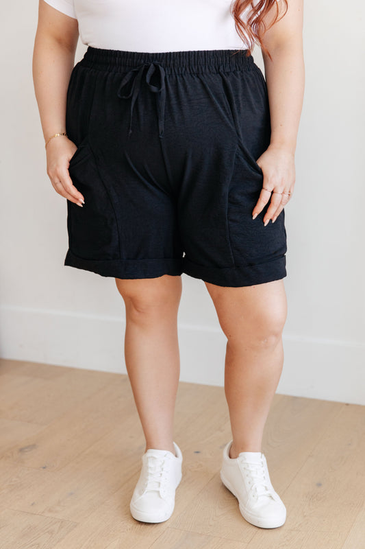 Plus size front view of Gracelyn Black Drawstring Shorts with oversized leg and functional drawstring.